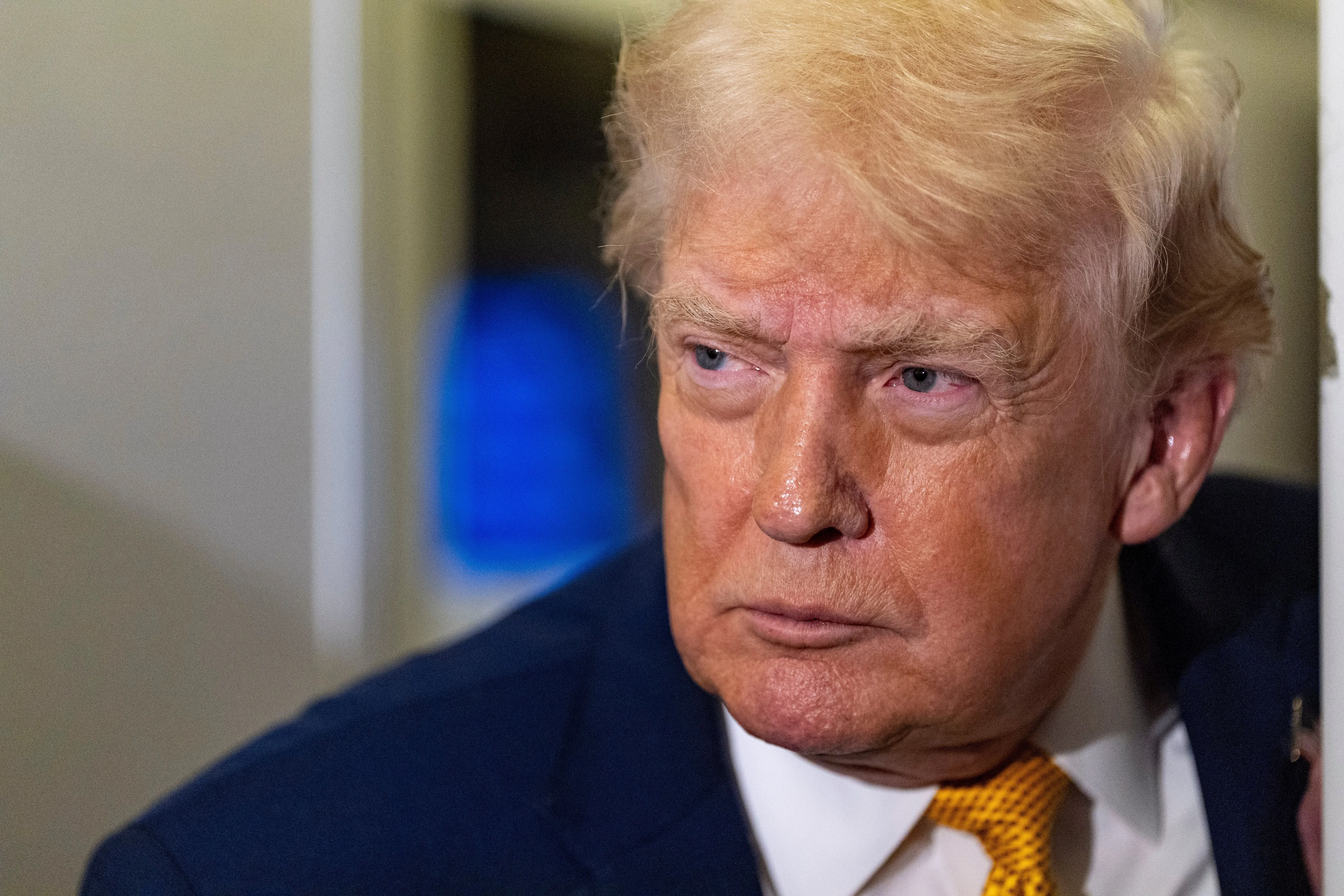 صورة للرئيس الأمريكي دونالد ترامب، يظهر فيها بتعبير جاد، مع خلفية غير واضحة. تعكس الصورة التوترات السياسية حول فنزويلا.