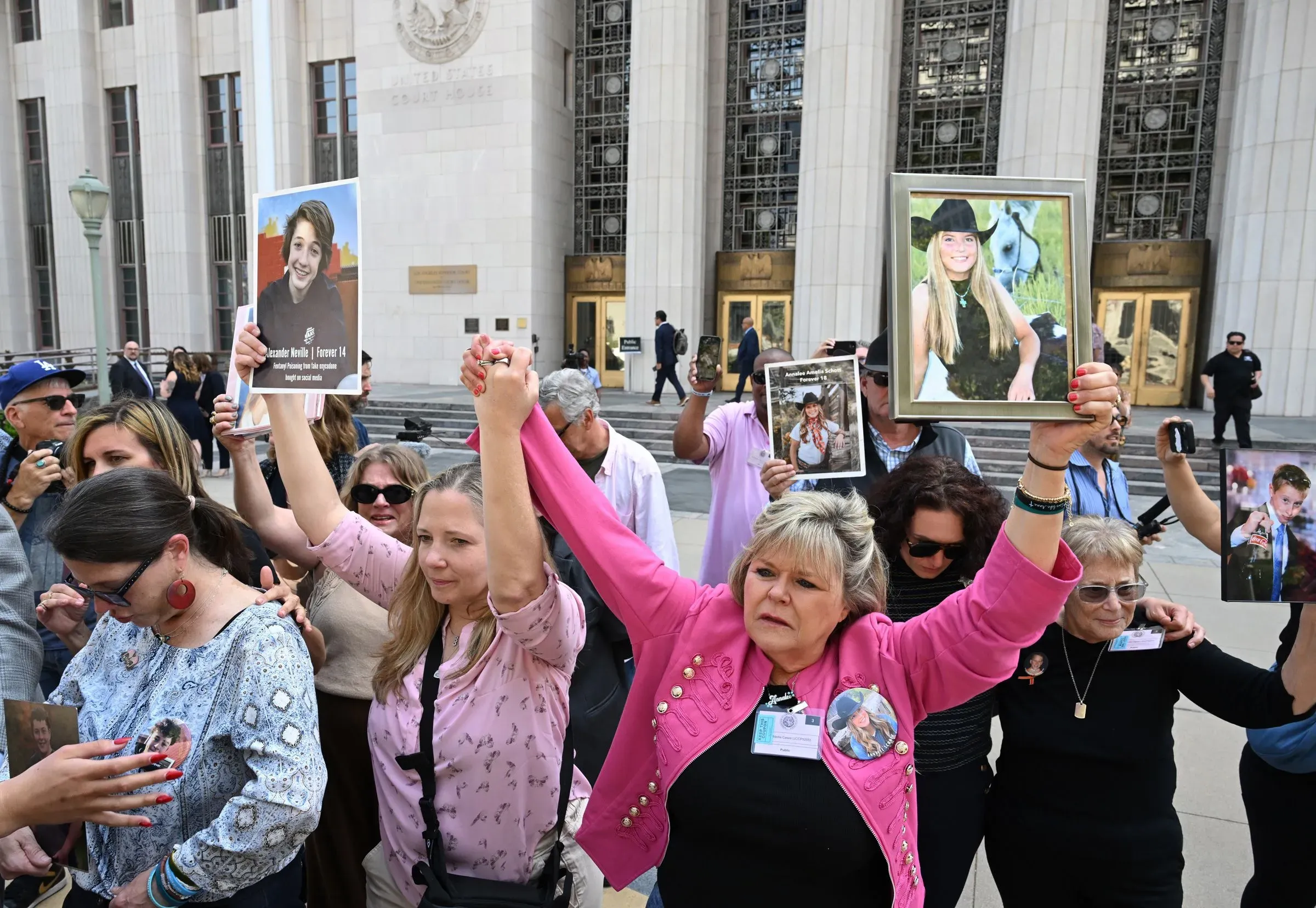 محتجون يحملون صورًا لأحبائهم أمام المحكمة، يعبرون عن مطالبهم بمسؤولية شركات التواصل الاجتماعي عن تأثيراتها على الصحة العقلية للشباب.