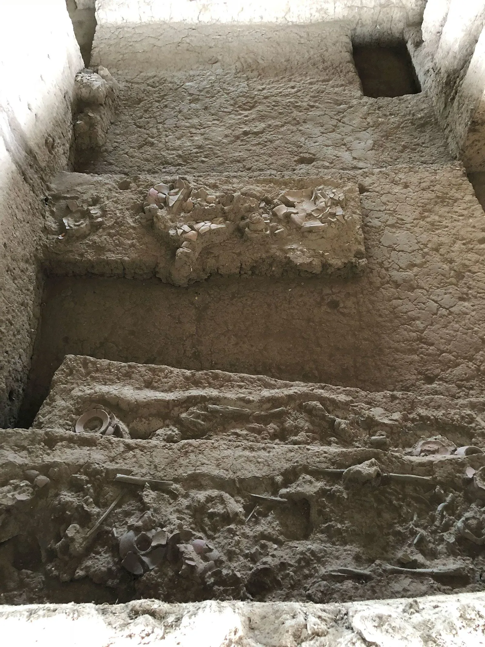 موقع دفن يعود للعصر الحجري الحديث في تايلاند، يظهر طبقات من التربة مع بقايا فخارية وعظام، مما يعكس عادات المجتمعات القديمة.