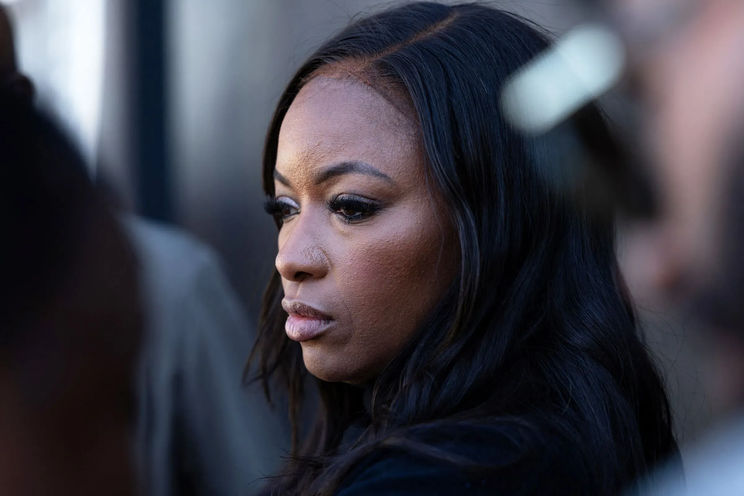 تظهر الصورة امرأة ذات شعر طويل ومجعد، تعبر عن تفكير عميق، مما يعكس أجواء الانتخابات التمهيدية في تكساس.