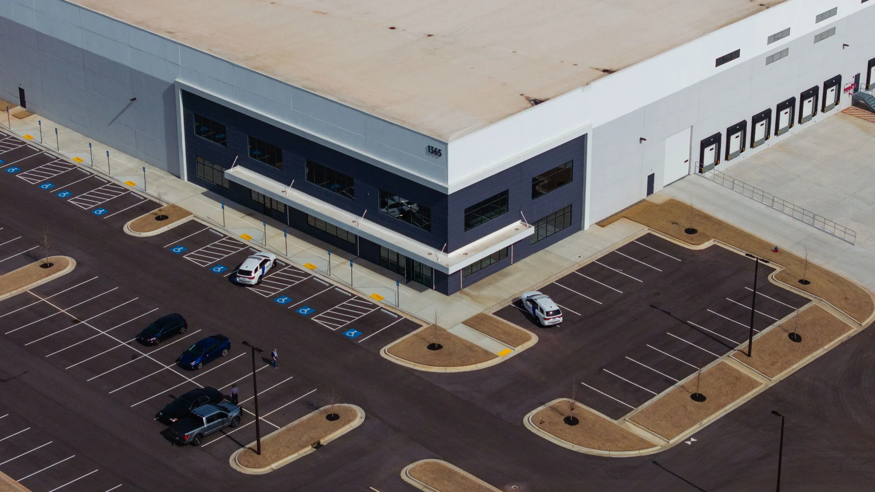 مركز احتجاز كبير تم تحويله من مستودع، يظهر فيه مواقف سيارات فارغة، يعكس التوسع في احتجاز المهاجرين خلال إدارة ترامب.