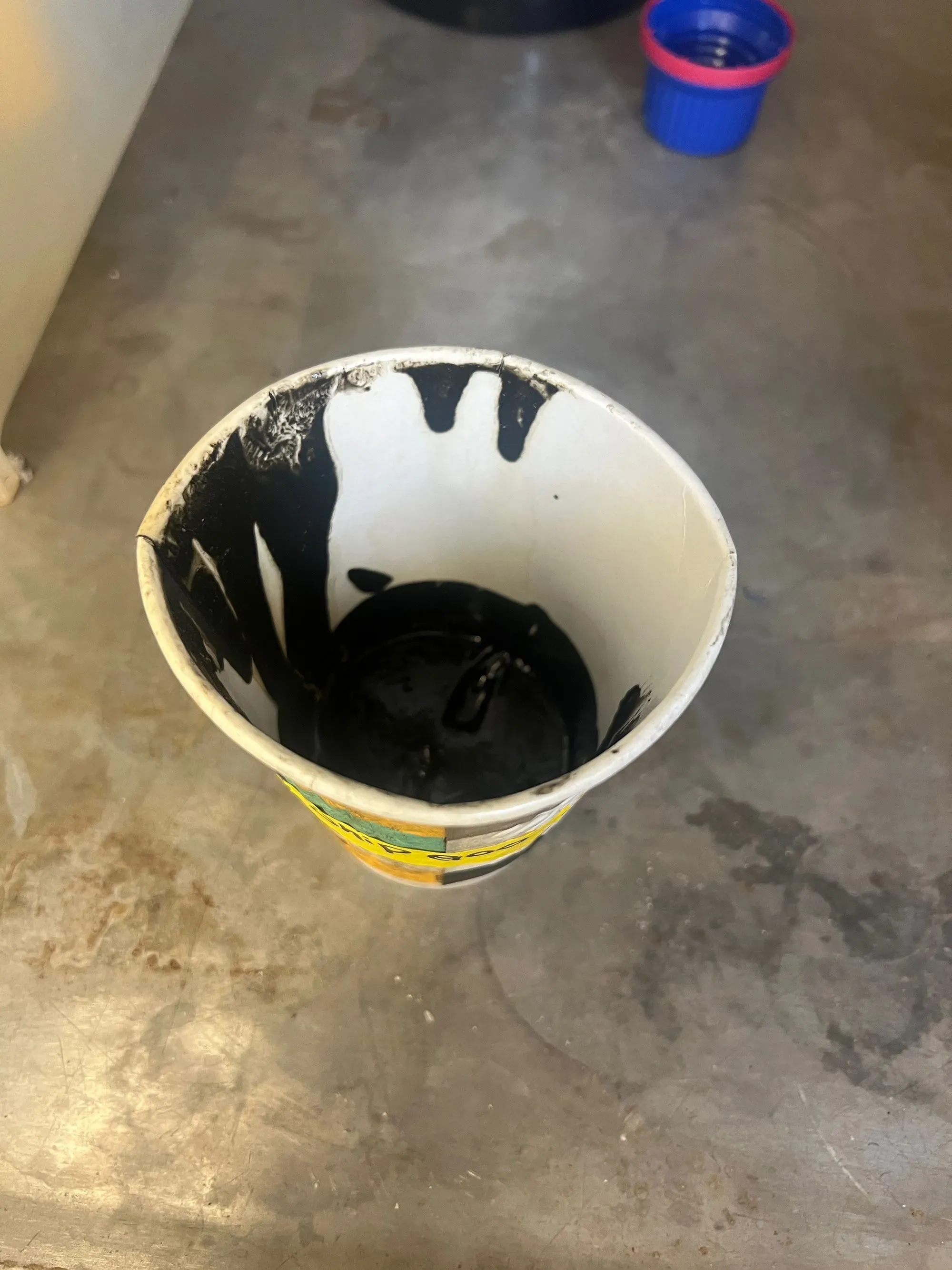 مادة لزجة سوداء تُجمع في كوب من قبل الباحثين، تُظهر حياة ميكروبية غير معروفة، تم اكتشافها على دفت سفينة الأبحاث "بلو هورون".