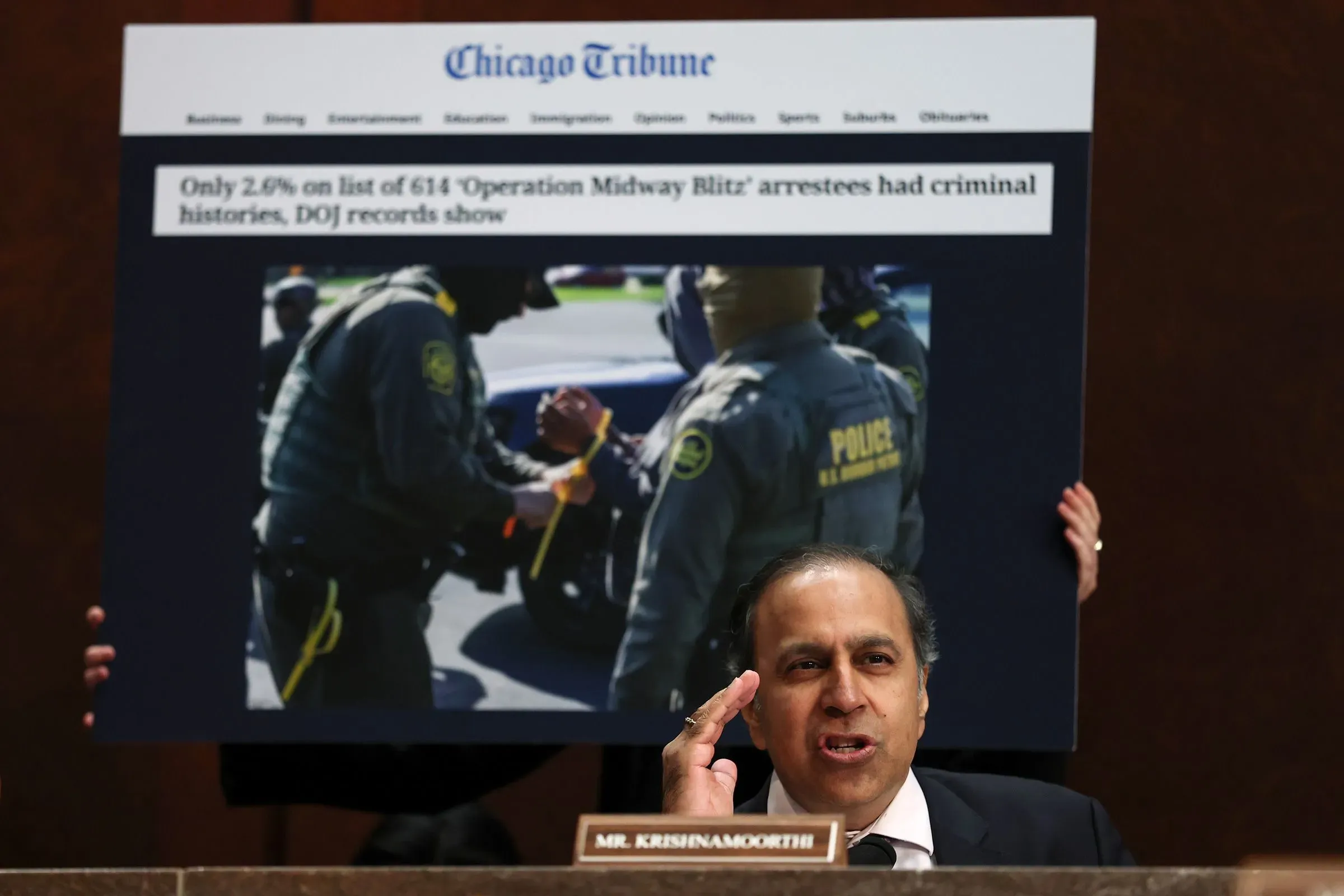 النائب كريشنامورثي يتحدث أثناء عرض صورة تتعلق بعملية اعتقال، مع التركيز على قضايا الهجرة وتأثيرها على الانتخابات.