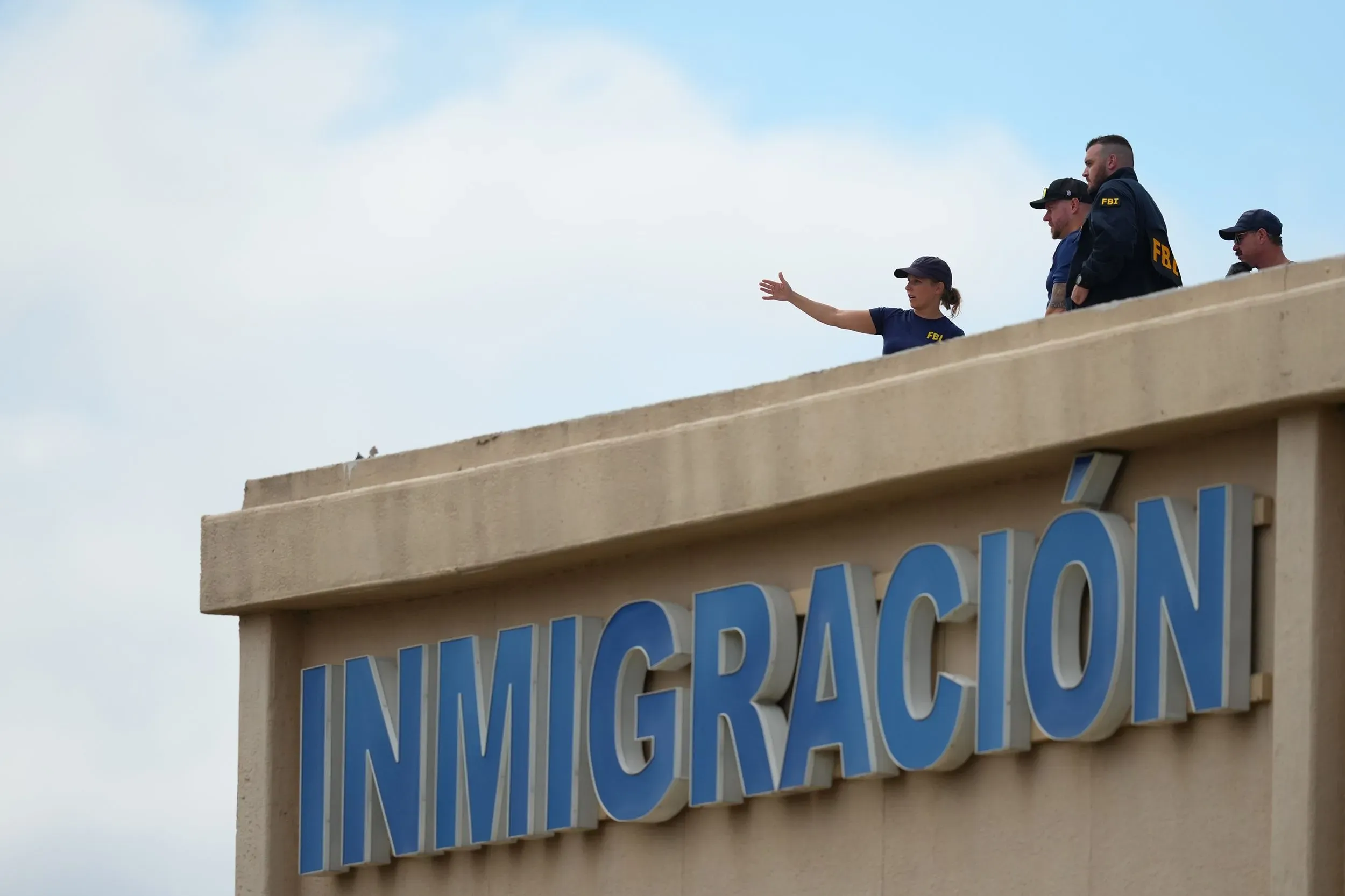 رجال أمن يتواجدون على سطح مبنى إدارة إنفاذ قوانين الهجرة والجمارك في دالاس، بعد حادث إطلاق نار أسفر عن إصابات.