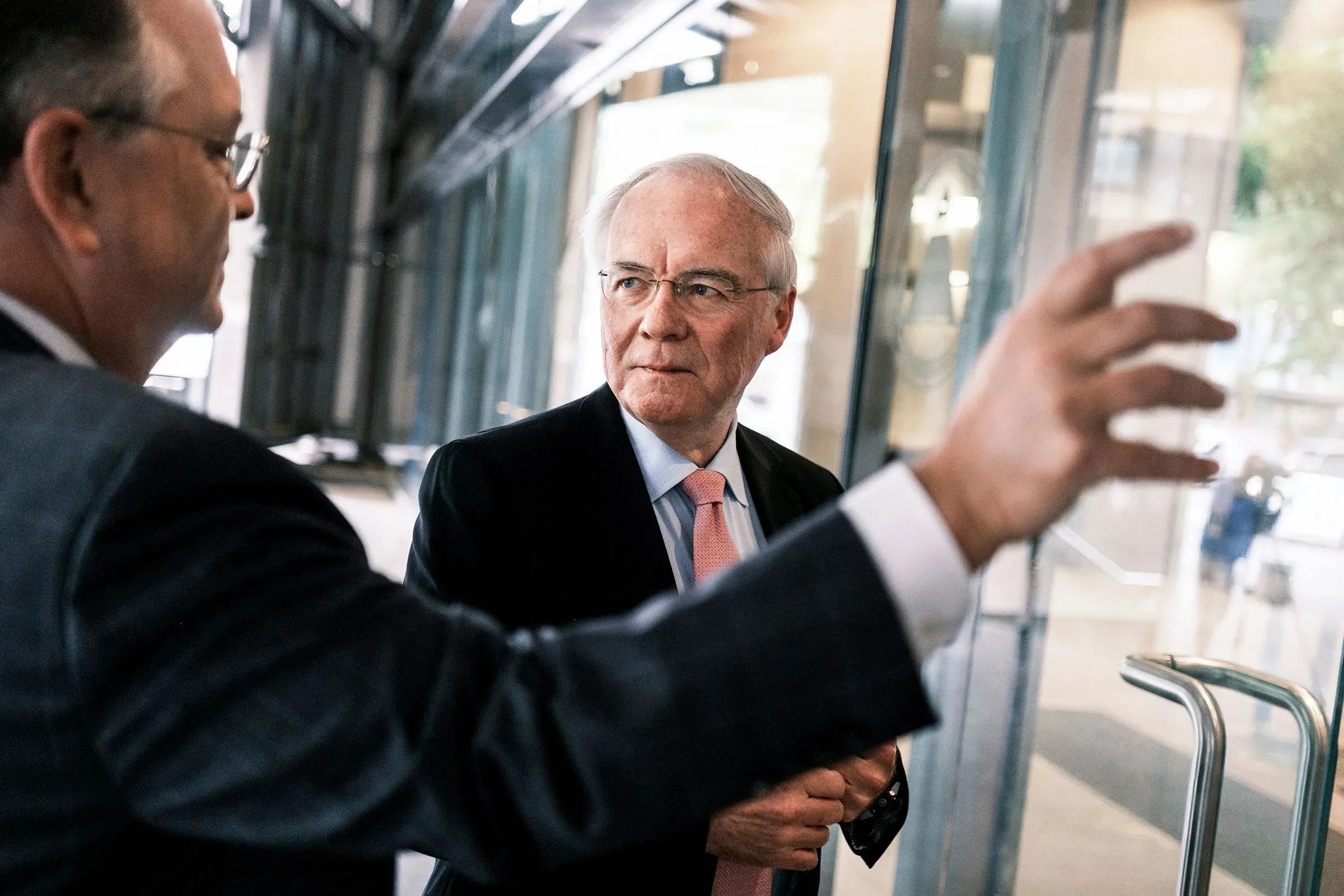 رودني ماكمولين، الرئيس التنفيذي السابق لشركة كروجر، يتحدث مع رجل آخر خارج مبنى الشركة بعد استقالته المفاجئة.