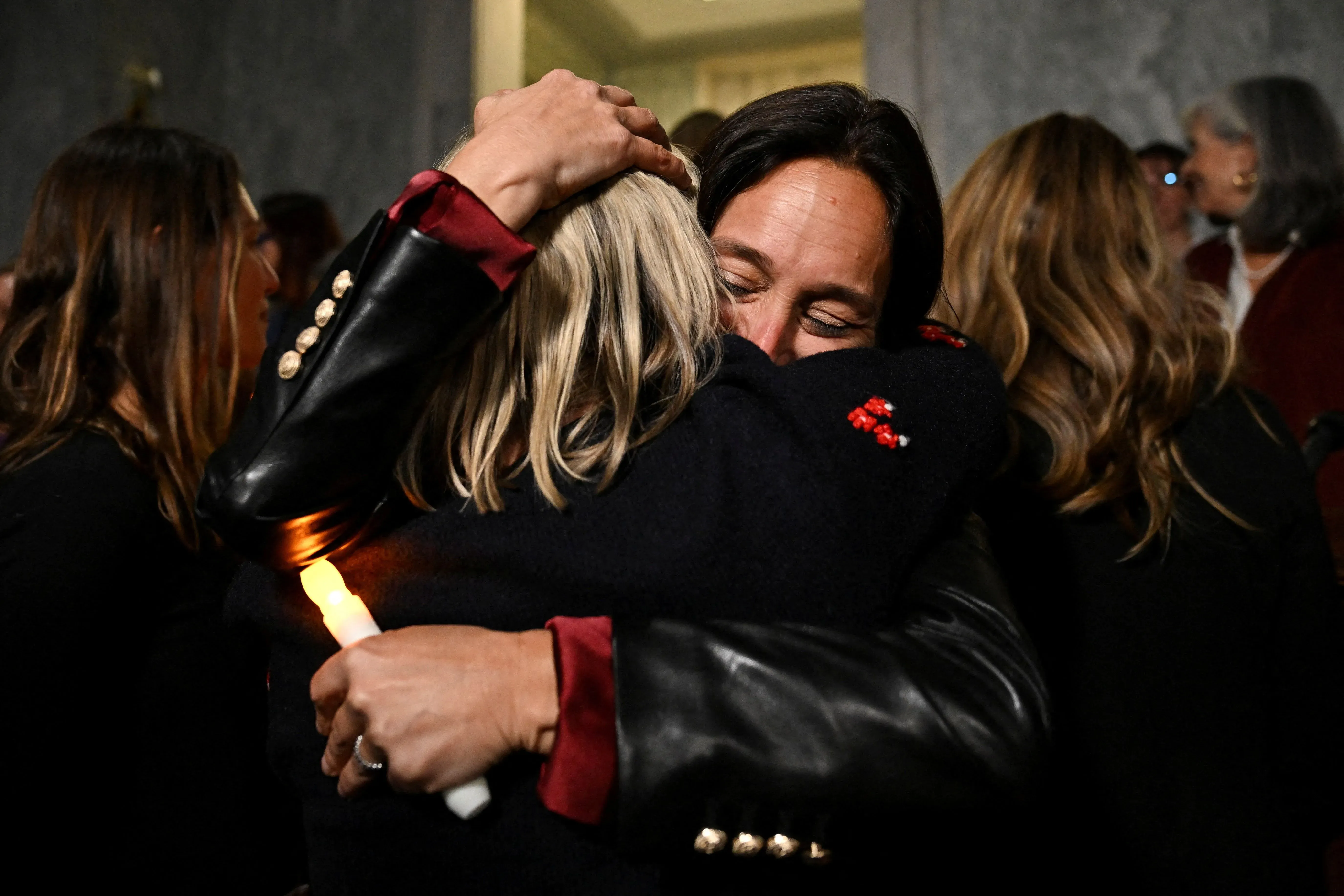 احتضان مؤثر بين امرأتين، تعبير عن الدعم والتضامن، في أجواء تركز على قضايا العدالة لضحايا الاعتداءات.