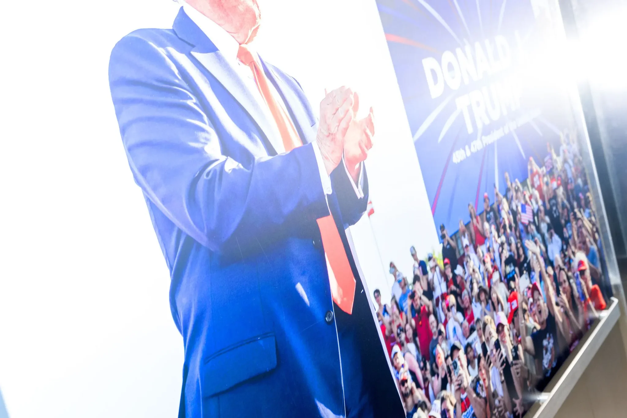 لوحة كبيرة لدونالد ترامب يصفق أمام جمهور حاشد في مؤتمر دالاس الجمهوري قبيل الانتخابات النصفية 2024.