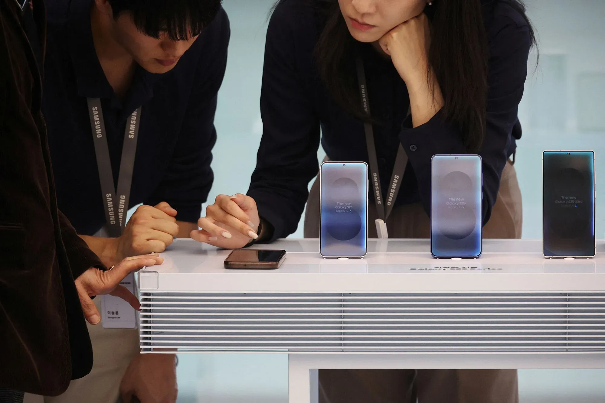 عرض لمجموعة من هواتف سامسونج Galaxy S26 في حدث إطلاق، حيث يتفاعل زوار مع الأجهزة الجديدة التي تضم ميزات الذكاء الاصطناعي.