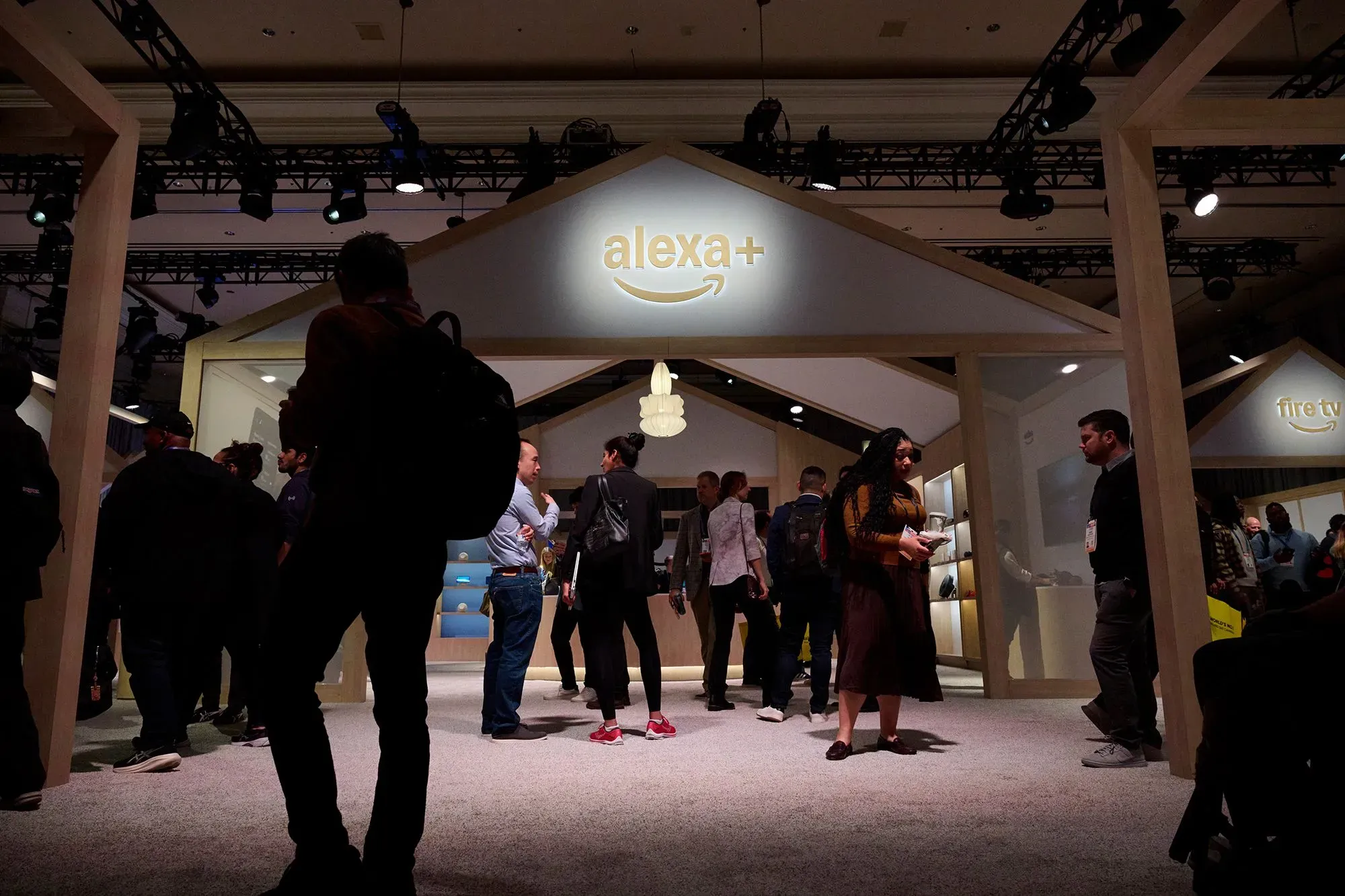 تجمع الصورة زوار معرض CES في لاس فيغاس حول منصة أليكسا+ من أمازون، مع عرض شعار أليكسا في الخلفية، مما يعكس الابتكارات في الذكاء الاصطناعي.