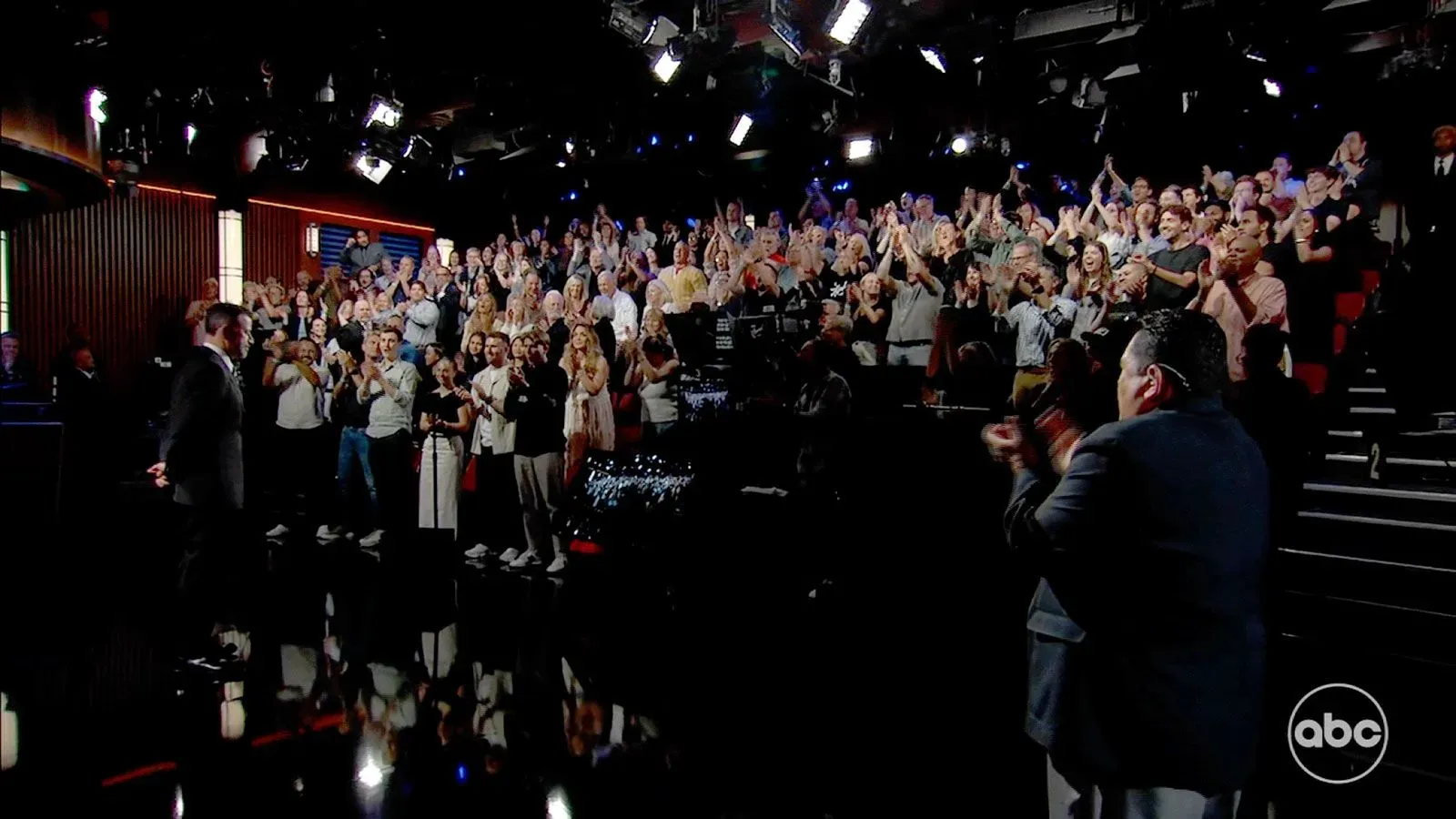 جيمي كيميل يقف أمام جمهور متحمس في استوديو برنامجه، حيث يشجع على حرية التعبير ويعبر عن شكره لدعم المشاهدين.