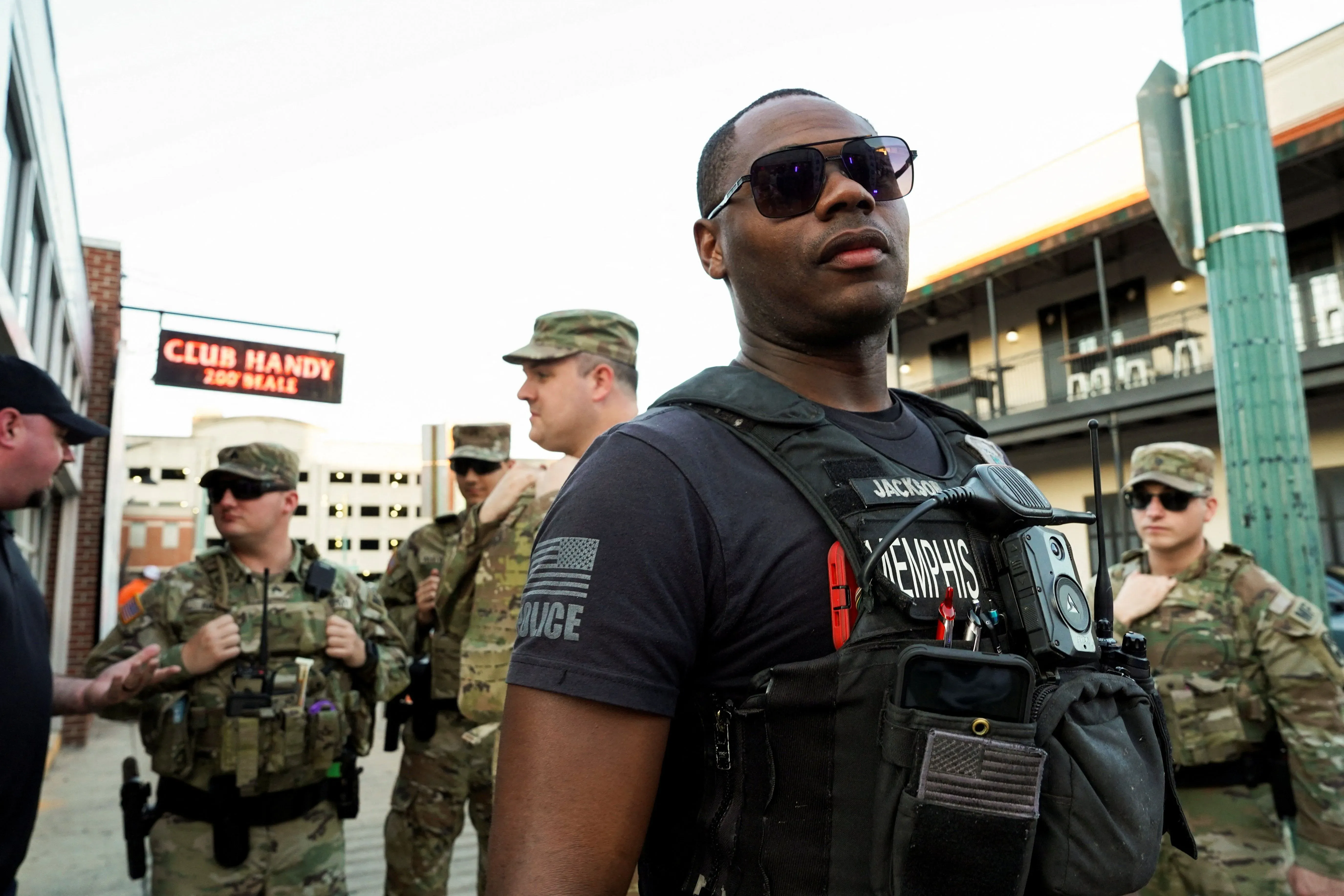 جنود من الحرس الوطني في بورتلاند يرتدون زيهم العسكري، مع تركيز على أحد الجنود الذي يرتدي نظارات شمسية، أثناء الاستعداد لمواجهة الاحتجاجات.