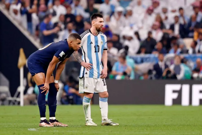 ليونيل ميسي وكيليان مبابي واقفان في ملعب كرة قدم خلال مباراة كأس العالم، يعكسان التنافس القوي بين الأرجنتين وفرنسا في نصف نهائي 2026.