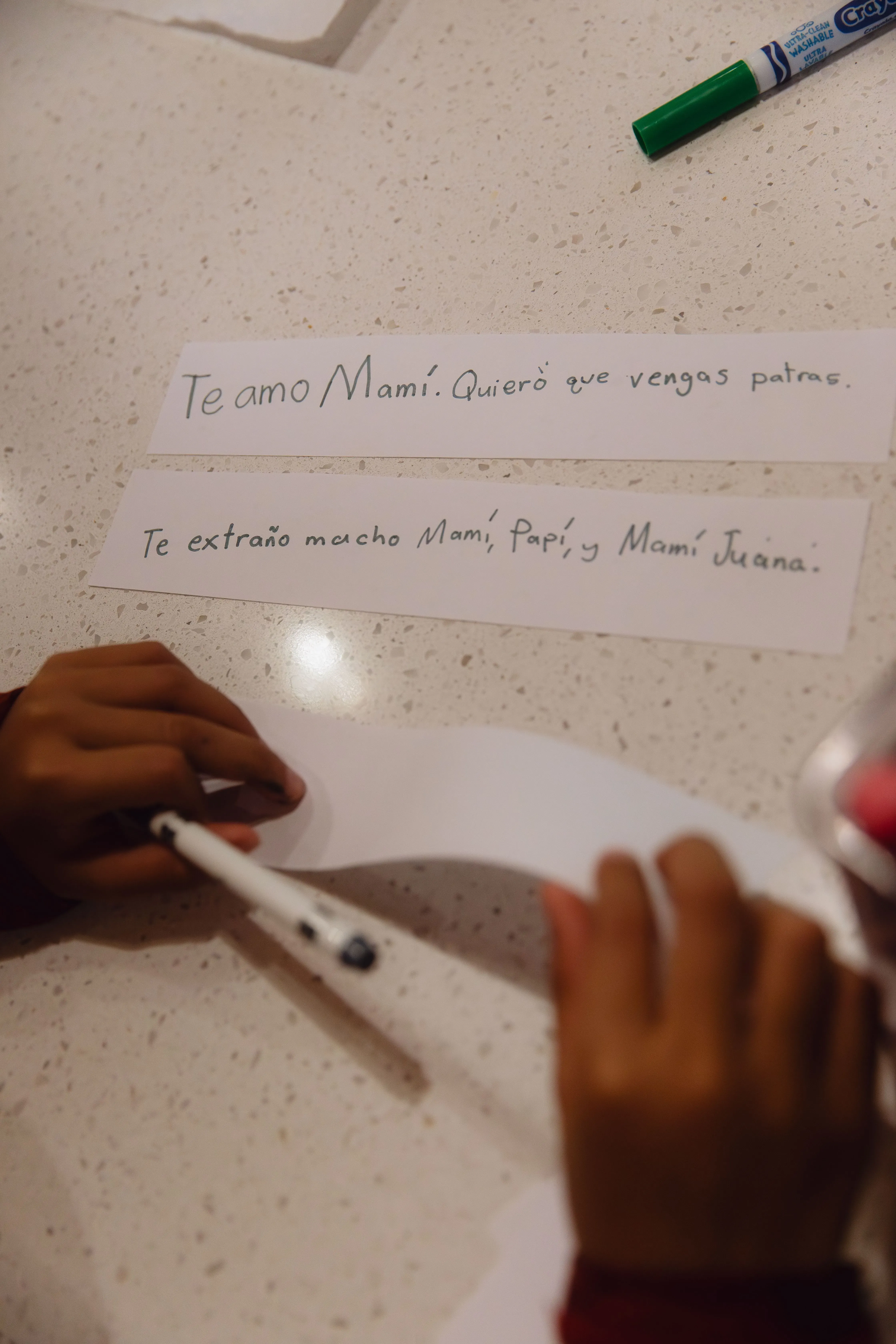 أطفال يكتبون رسائل إلى والدتهم، مع كلمات تعبر عن الحب والاشتياق، تعكس معاناتهم بسبب فصلهم عنها نتيجة إجراءات الهجرة.