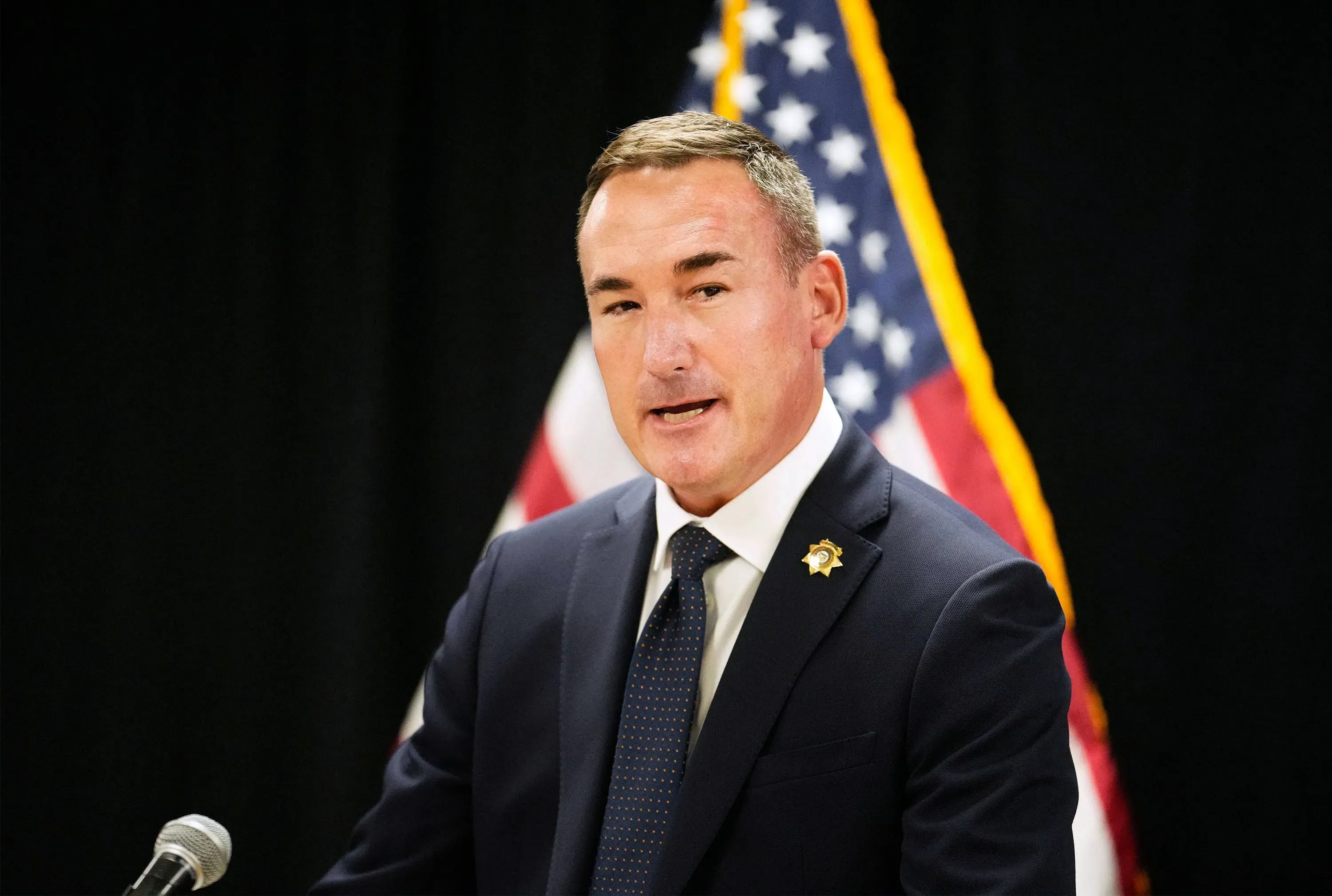 مدير إدارة الإصلاحيات في أريزونا يتحدث خلال مؤتمر صحفي حول تنفيذ حكم الإعدام في ريتشارد جرف، مع العلم الأمريكي خلفه.