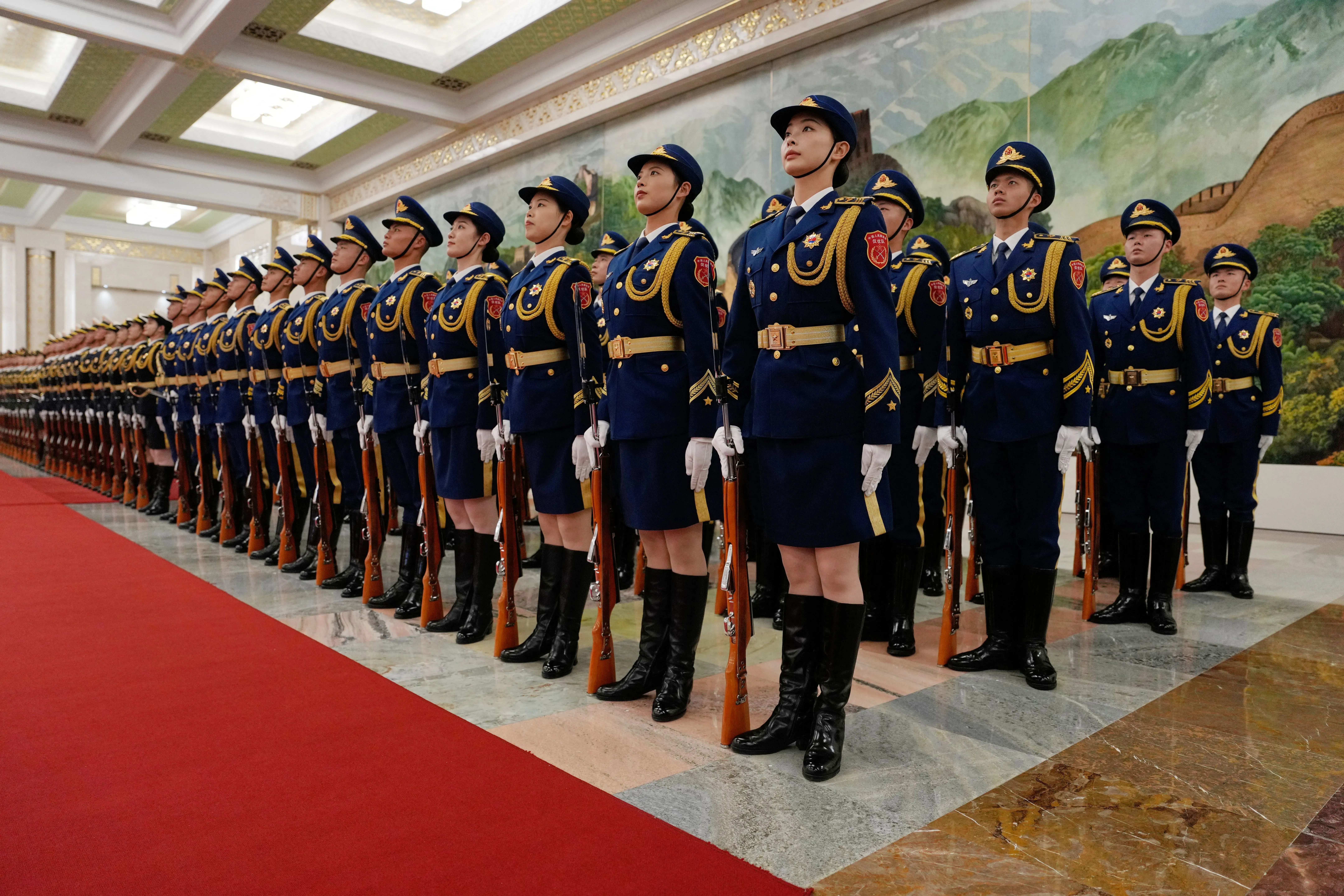 جنود يرتدون زيًا رسميًا يقفون في صفوف منتظمة خلال حدث رسمي في الصين، مما يعكس العلاقات الدبلوماسية المتزايدة مع الدول الغربية.