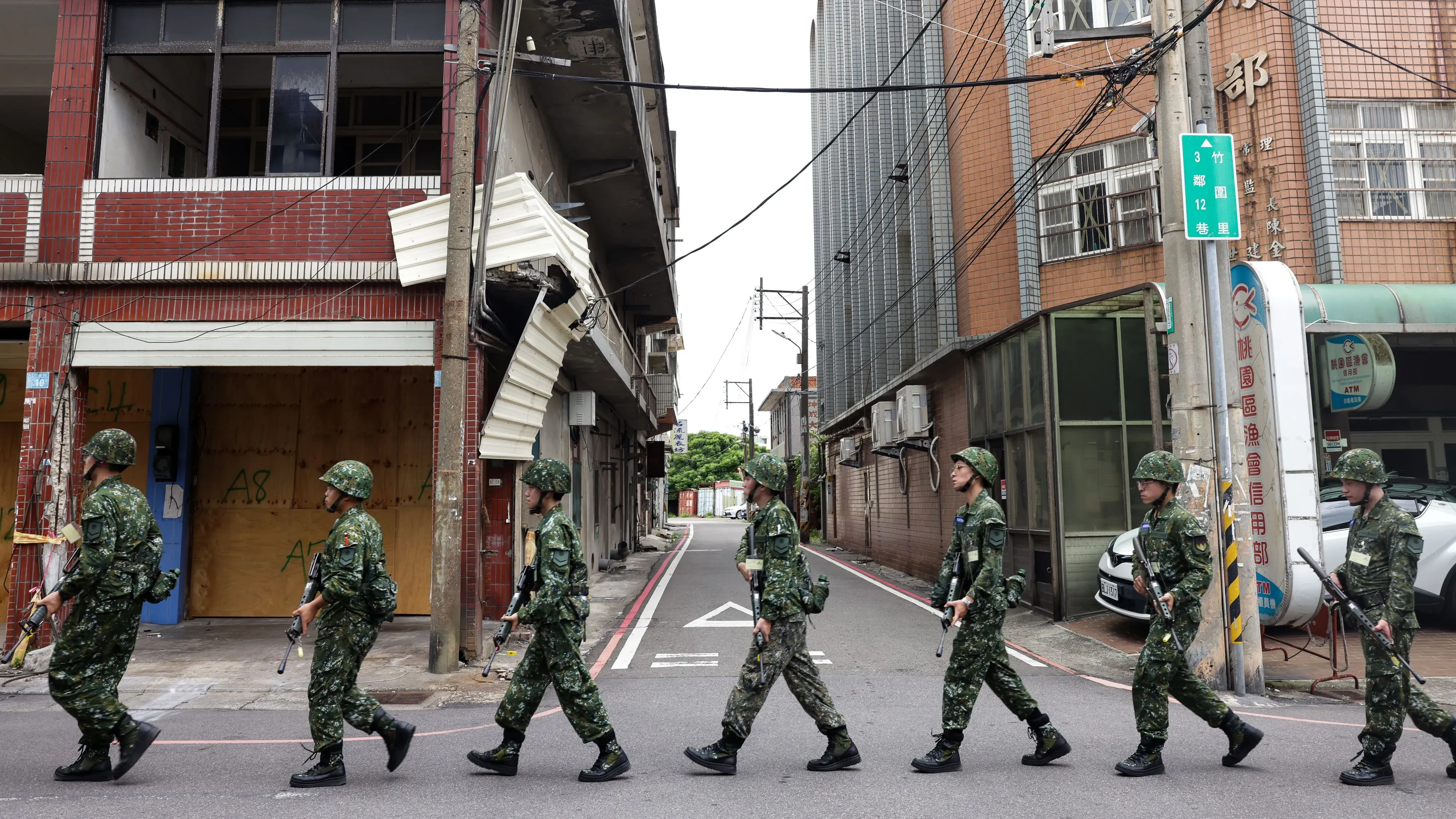 جنود تايوانيون يسيرون في شارع ضيق، يحملون أسلحتهم، في إطار تدريبات عسكرية وسط تصاعد التوترات مع الصين.