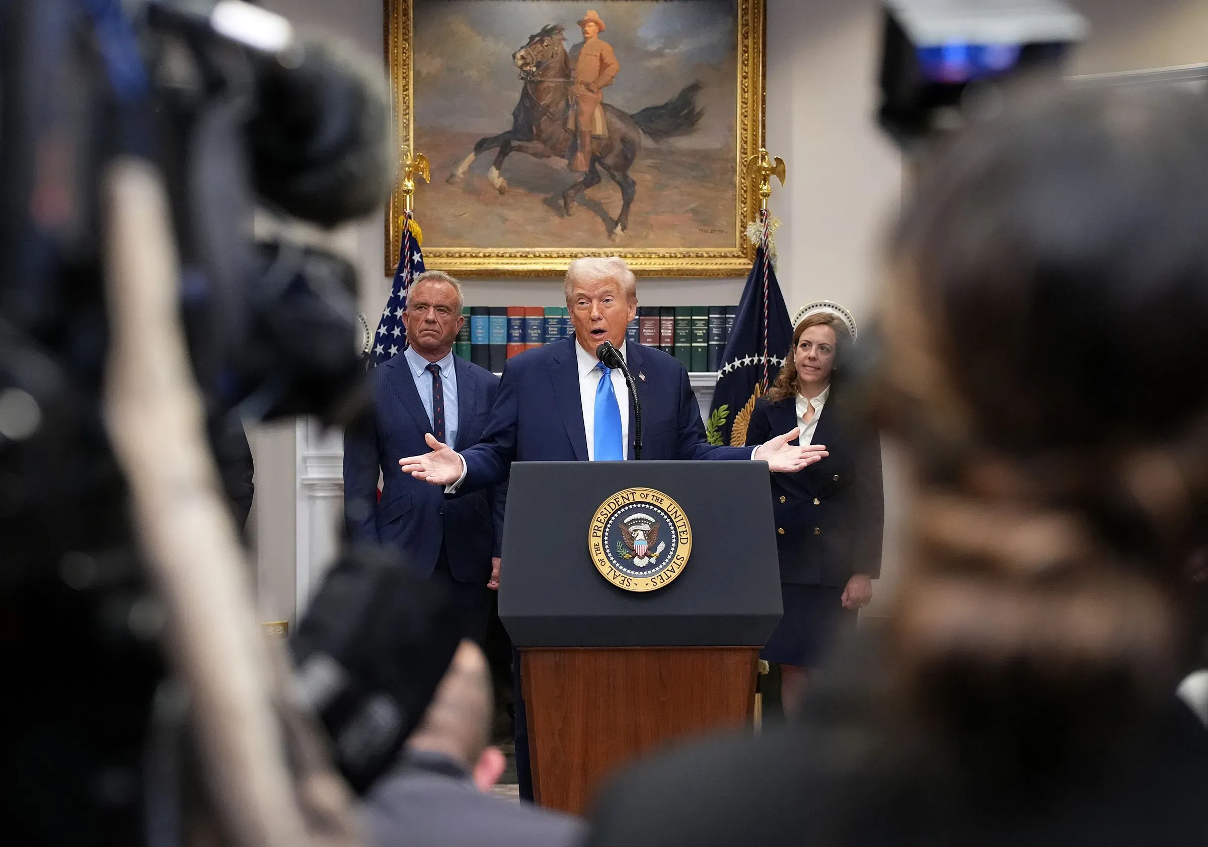 خطاب الرئيس ترامب في البيت الأبيض حول التوحد، مع وجود مسؤولين خلفه، يسلط الضوء على الجدل حول زيادة معدلات الإصابة بالتوحد.