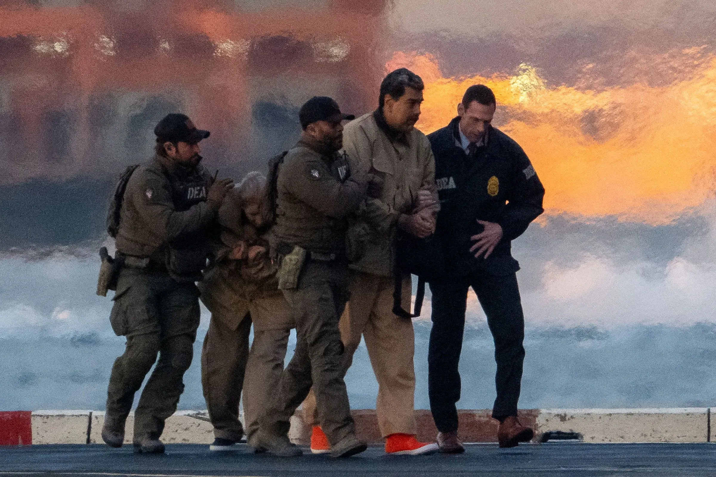 اعتقال نيكولاس مادورو، الرئيس الفنزويلي السابق، من قبل قوات الأمن، مع مشهد خلفي يعكس الأضواء.