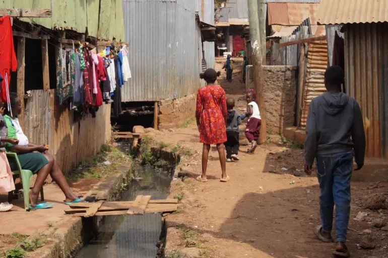 حي غيثوغورو في نيروبي، حيث تتجول العائلات في الأزقة الضيقة بين المنازل المعدنية، تعكس الفقر والتحديات اليومية.