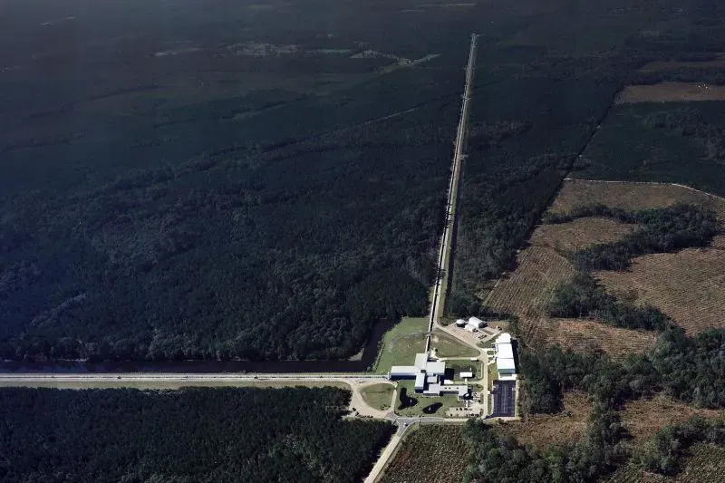 صورة جوية لموقع مرصد LIGO في ليفينغستون، لويزيانا، الذي رصد أكبر اندماج ثقوب سوداء تم تسجيله، ويظهر المرافق المحيطة والطبيعة الخضراء.