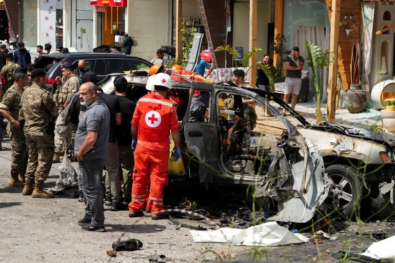 فرق الإنقاذ تعمل على إزالة الحطام من سيارة مدمرة في لبنان، بعد غارات إسرائيلية أدت إلى مقتل العديد من المدنيين، بما في ذلك أطفال.