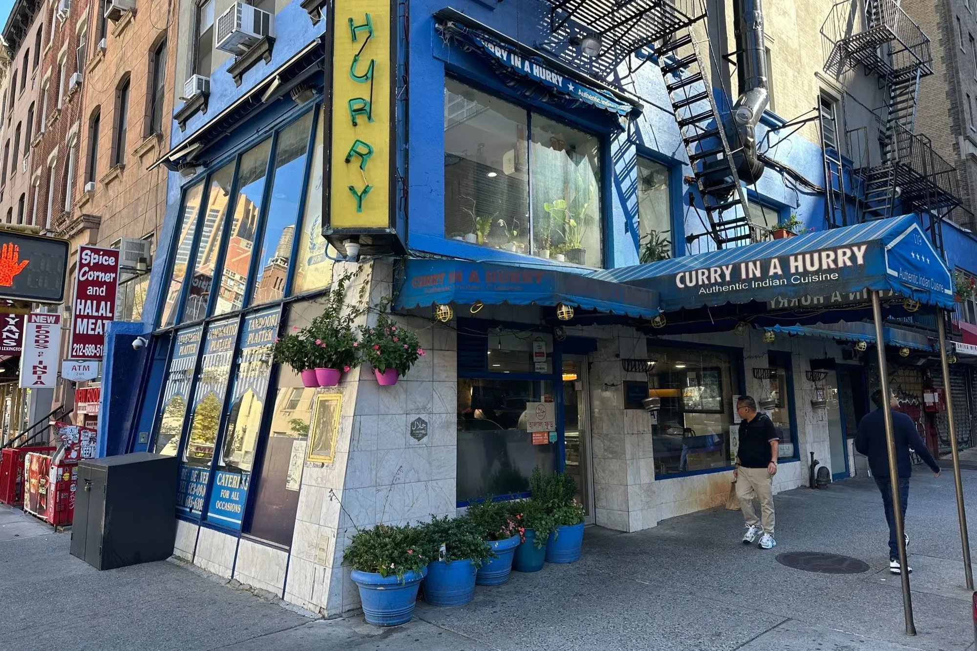واجهة مطعم "Curry in a Hurry" في مانهاتن، حيث يختلط جو المدينة بالحياة اليومية، ويشير إلى وجود أنشطة غير قانونية قريبة.