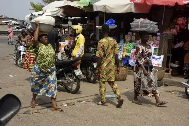 حركة نشطة في سوق دانتوكبا بكوتونو، حيث يتسوق الناس ويعود التجار لبيع بضائعهم بعد محاولة الانقلاب الفاشلة.