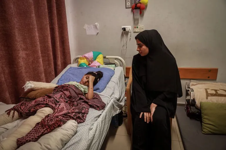 هالا، الطفلة الناجية من قصف في غزة، تتلقى الرعاية في المستشفى، بينما تجلس عمّتها بجوارها، تعبيرات الحزن والقلق واضحة.