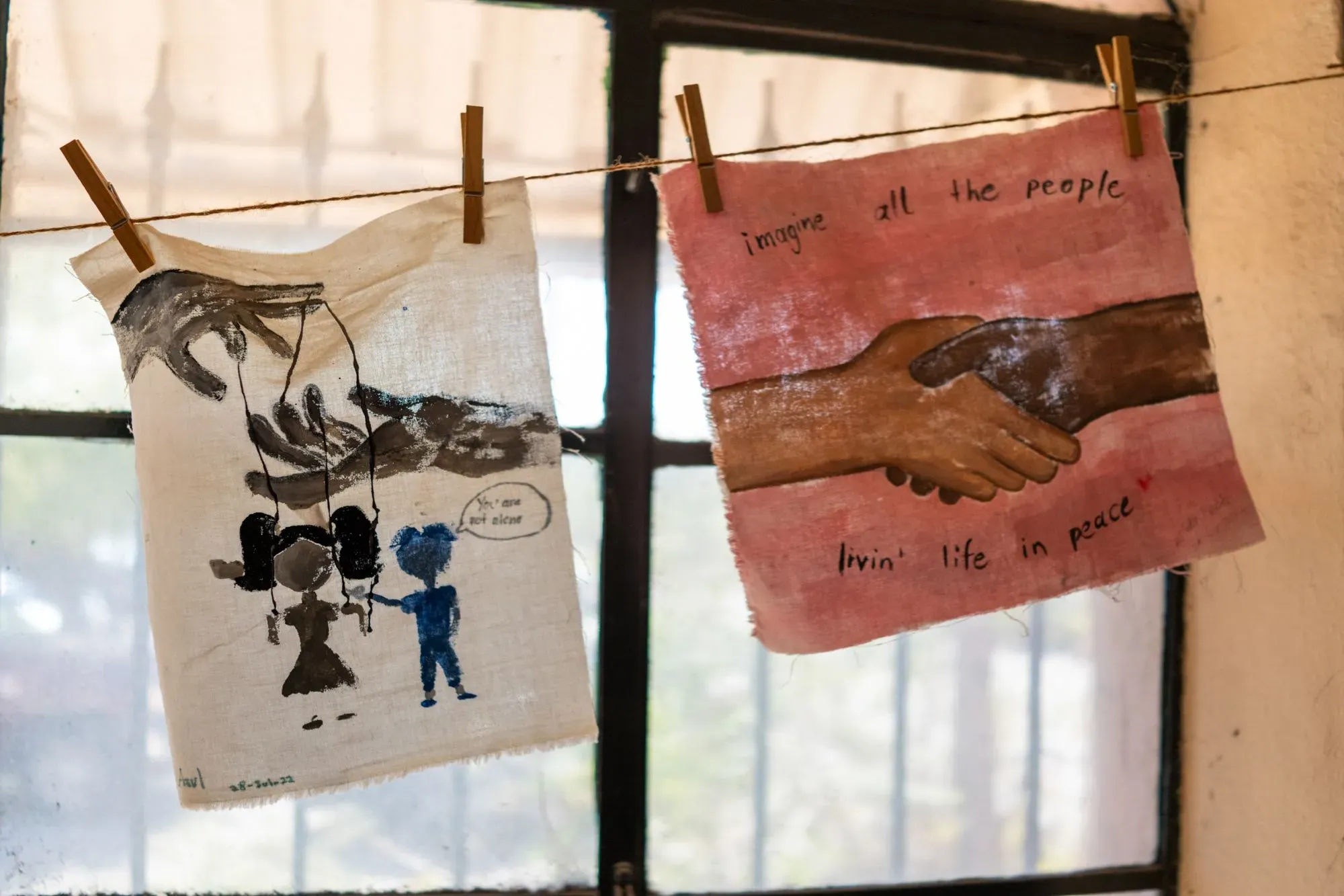 لوحات فنية معلقة تظهر أيادي متشابكة ورموز للسلام، تعكس قيم التعاون والتفاهم بين الثقافات.