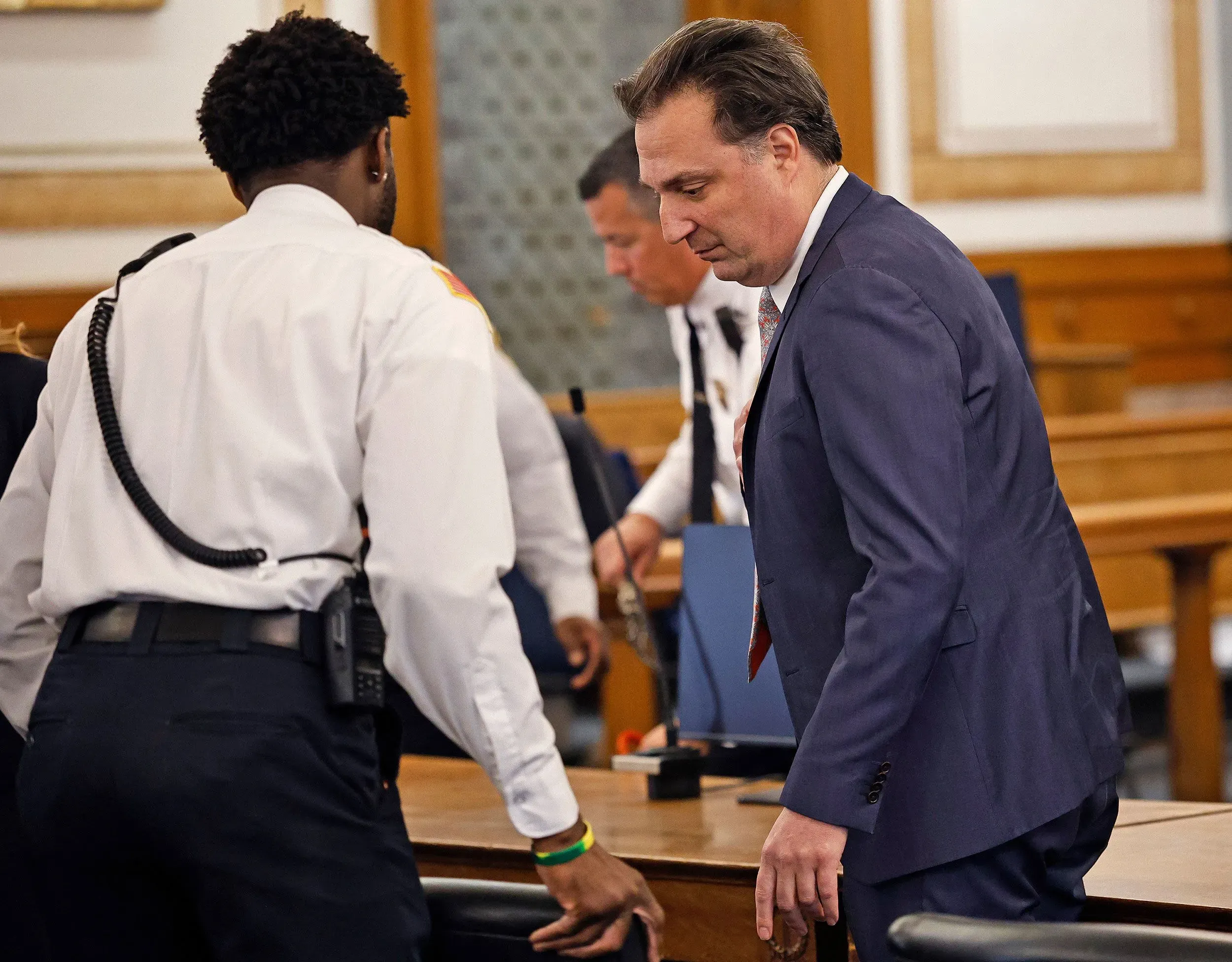 براين والش يدخل قاعة المحكمة، حيث ينتظر الحكم عليه بتهمة قتل زوجته آنا، وسط أجواء مشحونة بالترقب والقلق.