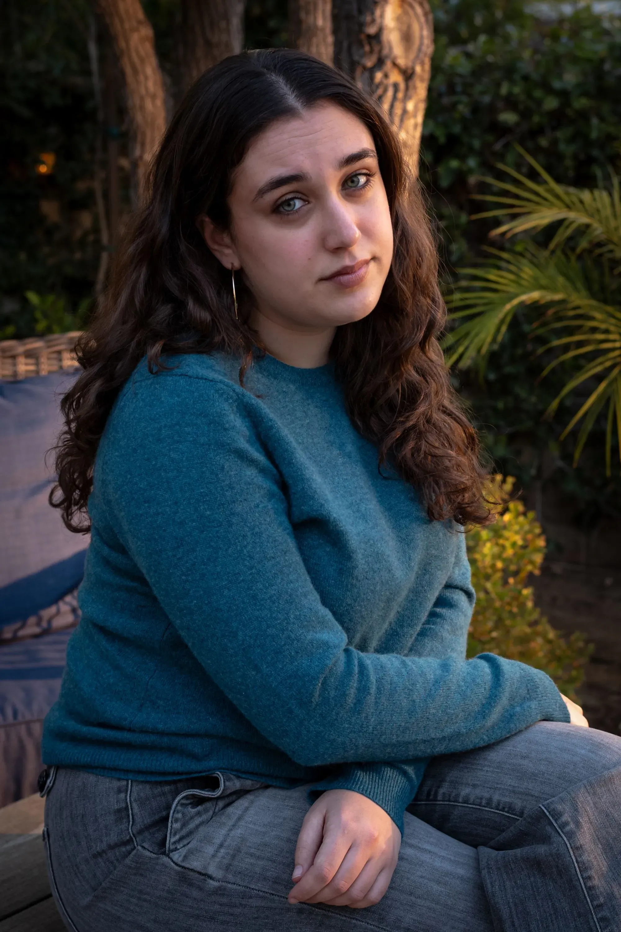 ميا تريتا، الناجية من إطلاق نار في المدرسة، تجلس في حديقة، تعكس مشاعر القلق والتوتر مع عودتها إلى جامعة براون بعد الحادث.