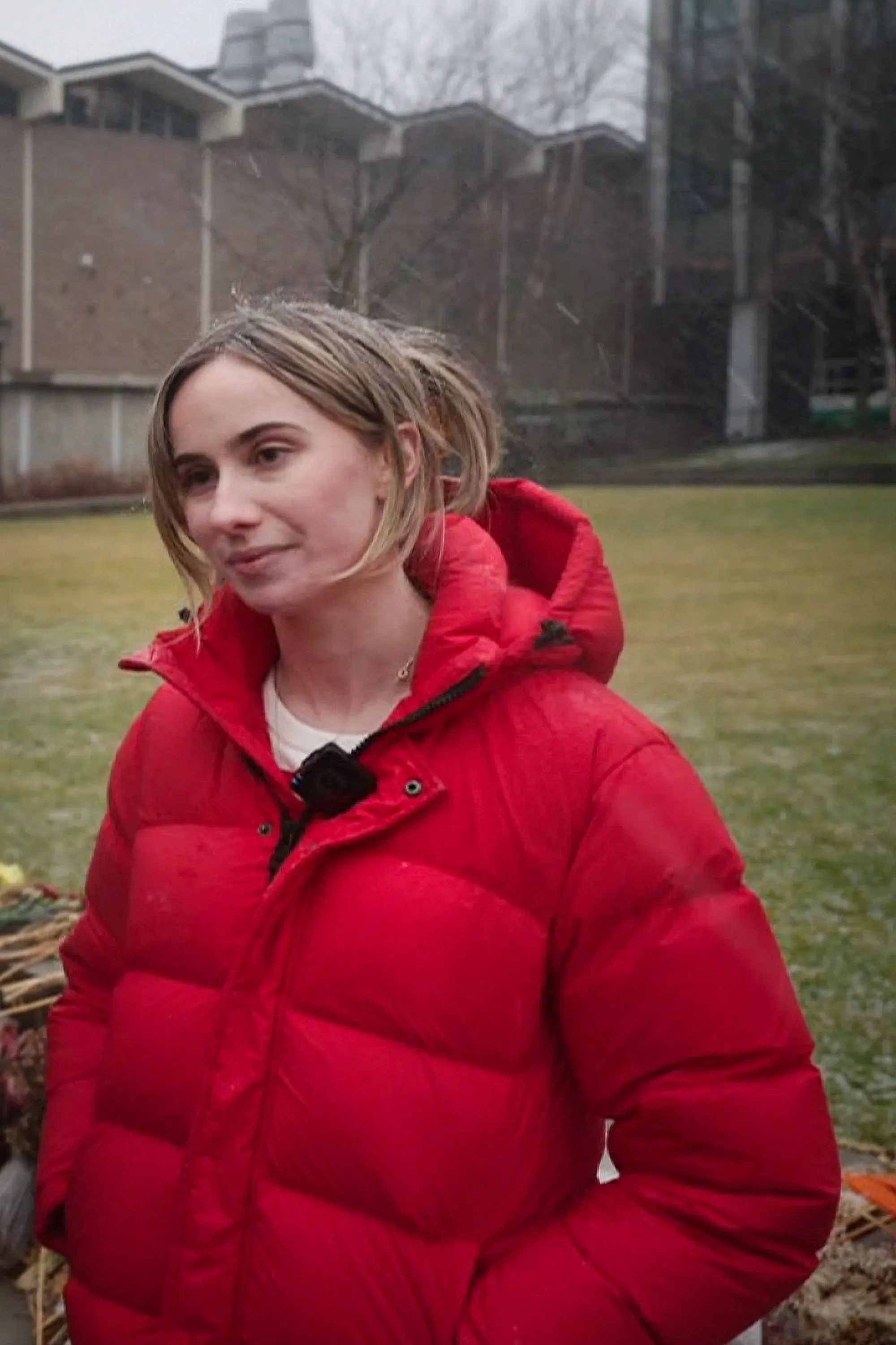 ميا تريتا، الناجية من إطلاق نار في جامعة براون، تتحدث في حرم الجامعة، مرتدية سترة حمراء، وسط أجواء شتوية.