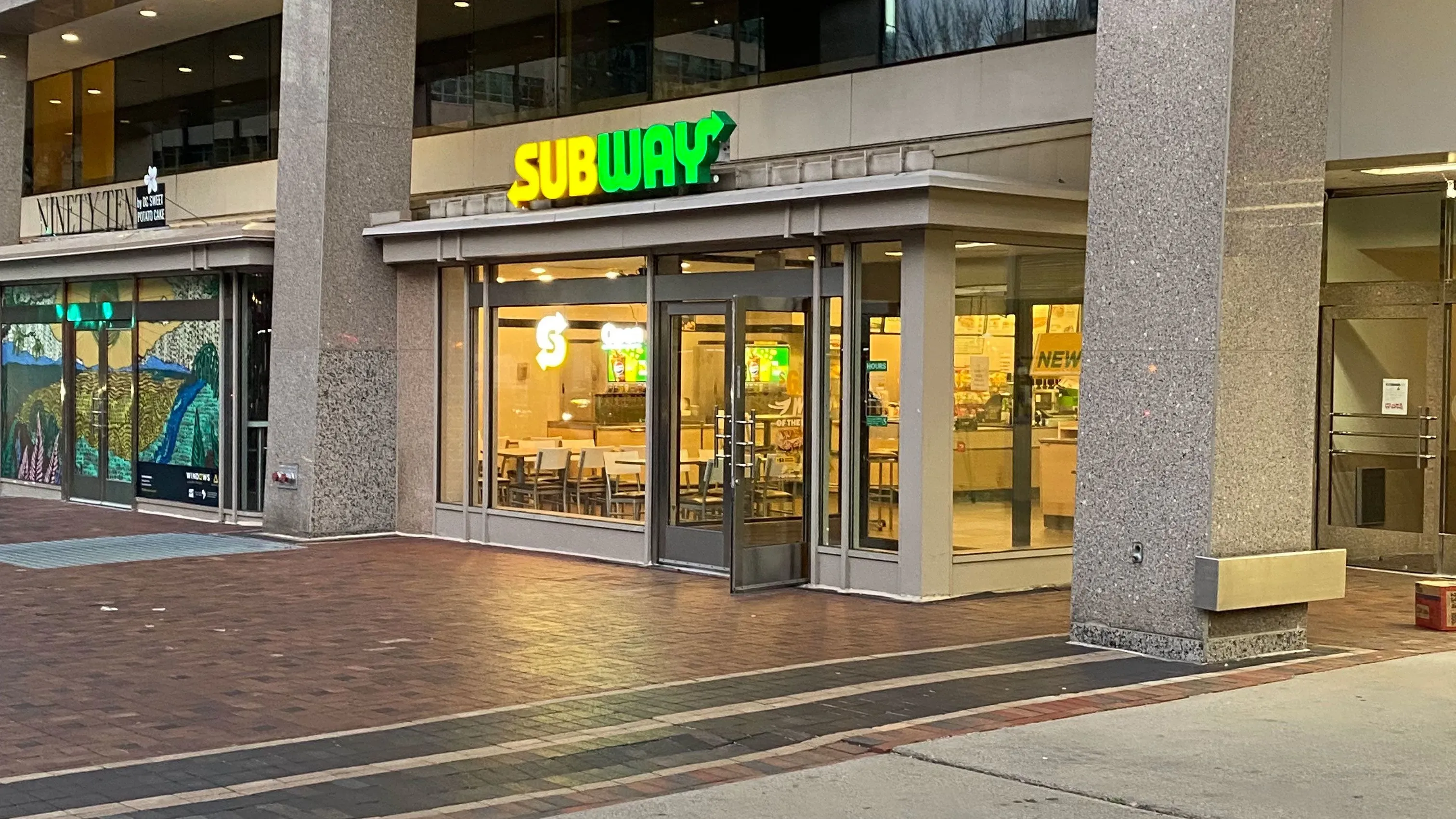 واجهة متجر "ساب واي" في وسط العاصمة واشنطن، مع إضاءة واضحة ولافتة ملونة، تعكس الأجواء المحيطة بعد حادثة إطلاق النار.