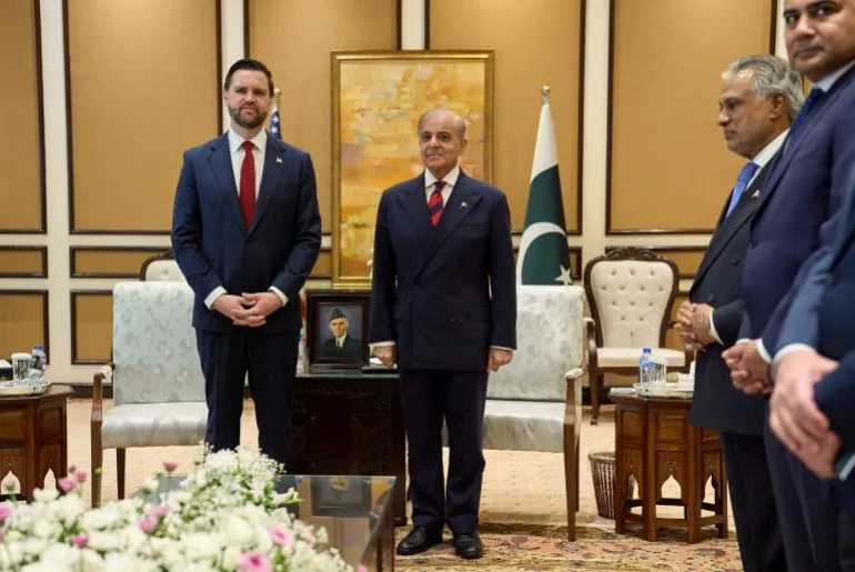 اجتماع رسمي يضم مسؤولين حكوميين، يتوسطهم رئيس وزراء باكستان، مع العلم الباكستاني في الخلفية، يعكس التعاون الدولي في ظل الأزمات.