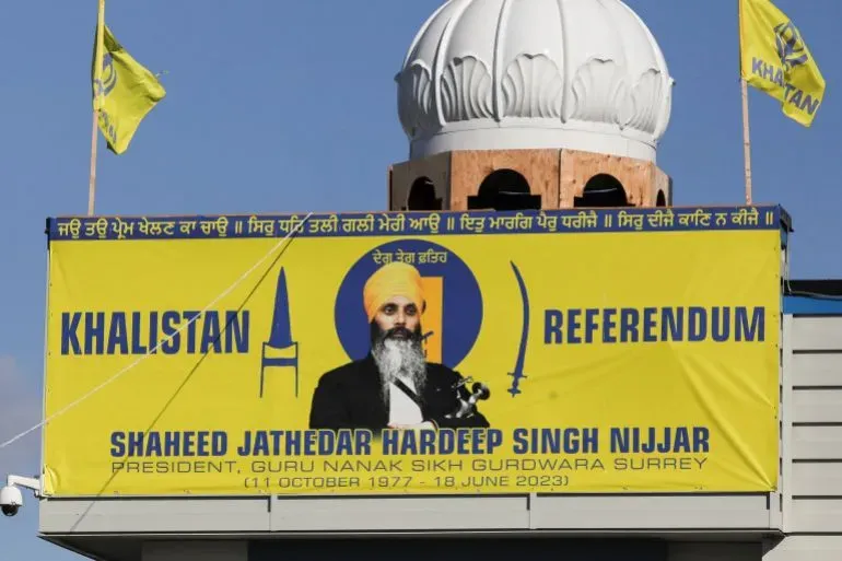 لافتة كبيرة تحمل صورة هارديب سينغ نيجار، مع شعار "خاليستان" وتاريخ ميلاده ووفاته، مثبتة على مبنى مع قبة ومجموعة من الأعلام.
