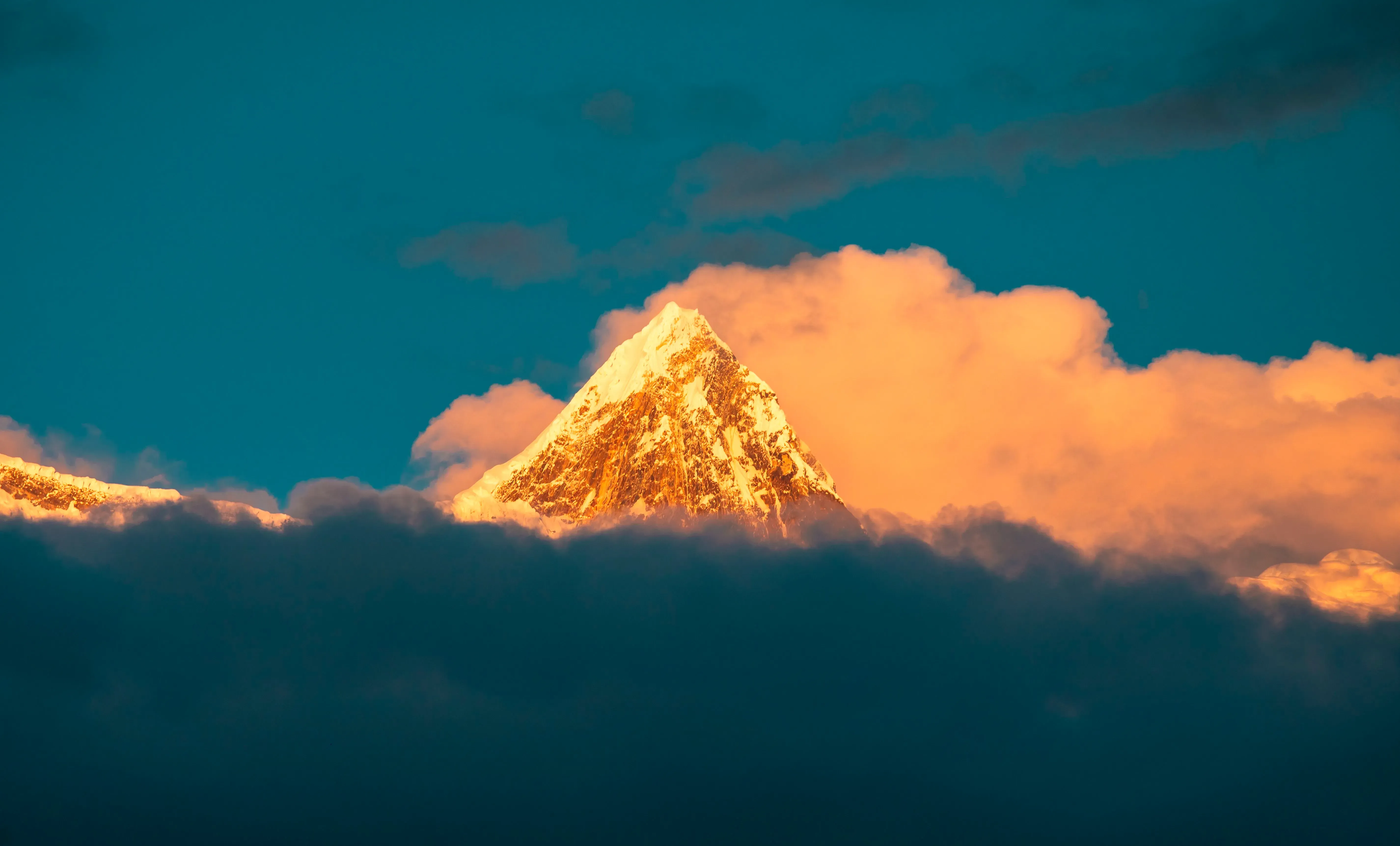 قمة جبلية مغطاة بالثلوج تبرز من السحب، تمثل المنطقة التي سيُبنى فيها مشروع الطاقة الكهرومائية الضخم في التبت.