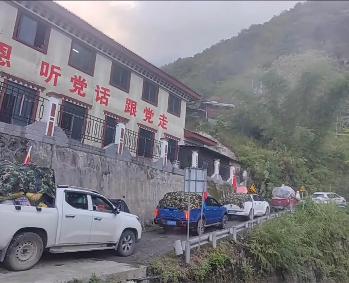 مركبات تحمل لافتات على جانب طريق في منطقة نائية من التبت، بالقرب من مشروع الطاقة الكهرومائية الضخم.