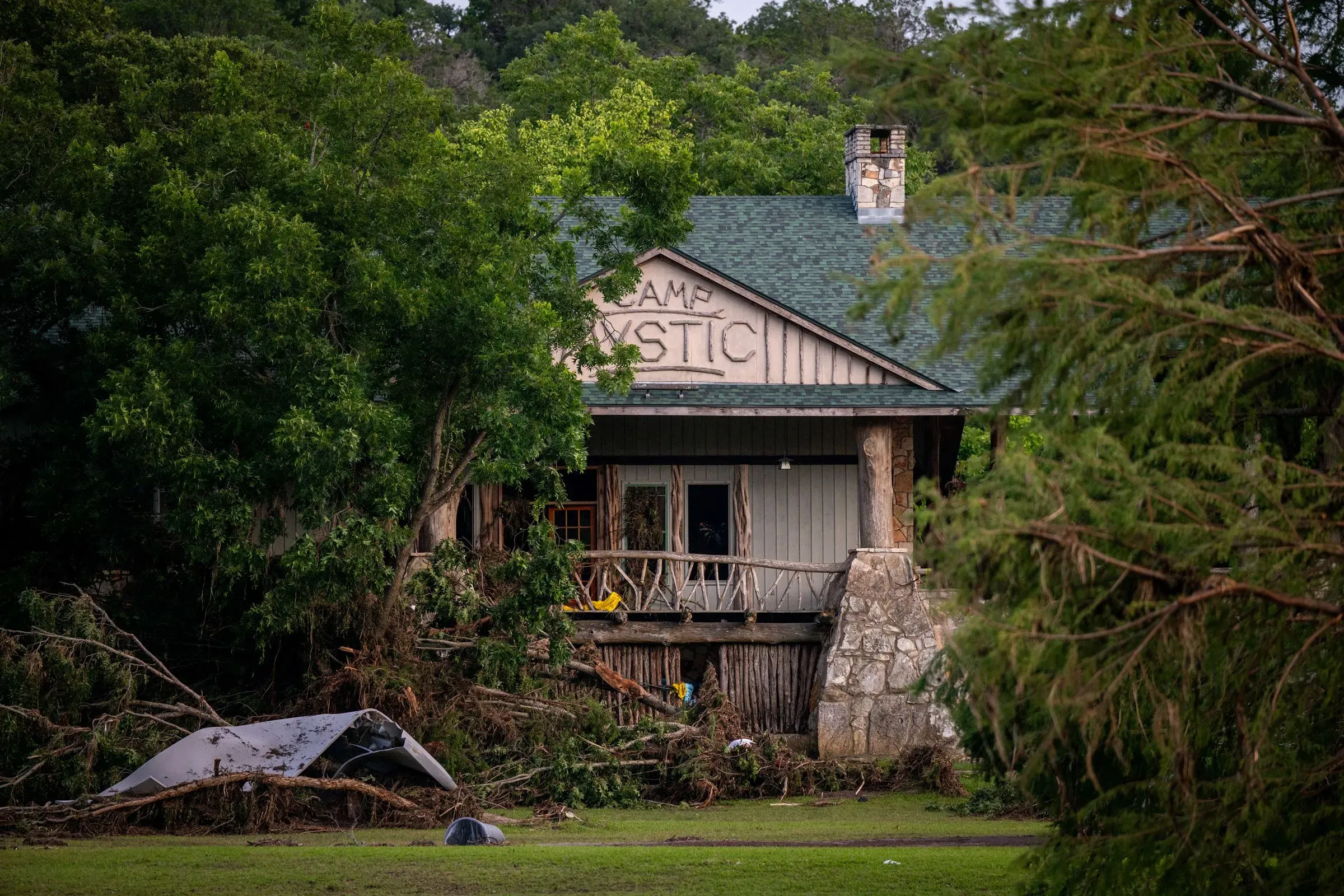 مبنى مخيم ميستيك في تكساس محاط بأشجار بعد الفيضانات، يظهر آثار الدمار والخراب الذي خلفته الكارثة.