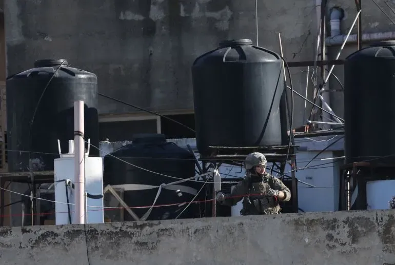 جندي إسرائيلي يقف بالقرب من خزانات المياه في نابلس، وسط أجواء مشحونة بعد هدم منزل عائلة صنوبر.