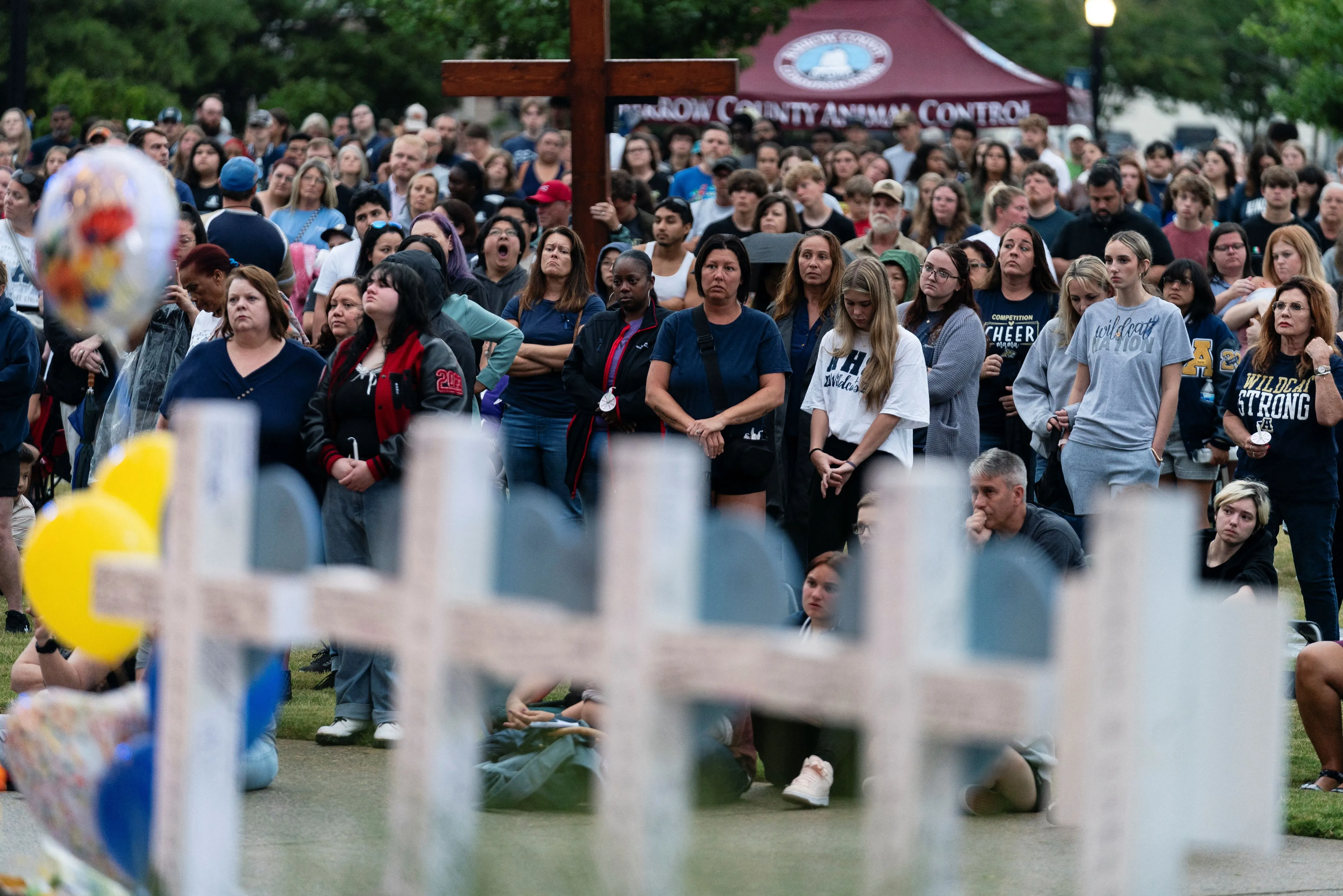 تجمع حشود من الناس في حديقة لإحياء ذكرى ضحايا إطلاق النار في مدرسة أبالاتشي الثانوية، مع تعبيرات الحزن والقلق.