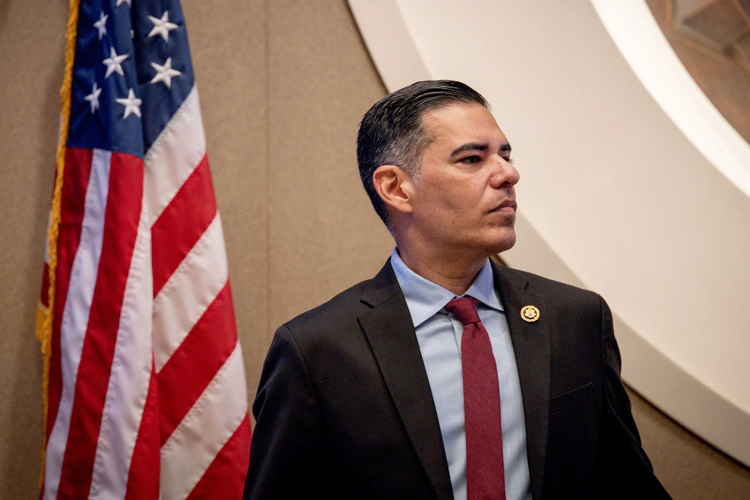 النائب روبرت غارسيا يقف بجانب العلم الأمريكي، معبرًا عن قلقه بشأن المساءلة القانونية لمسؤولي إدارة ترامب.