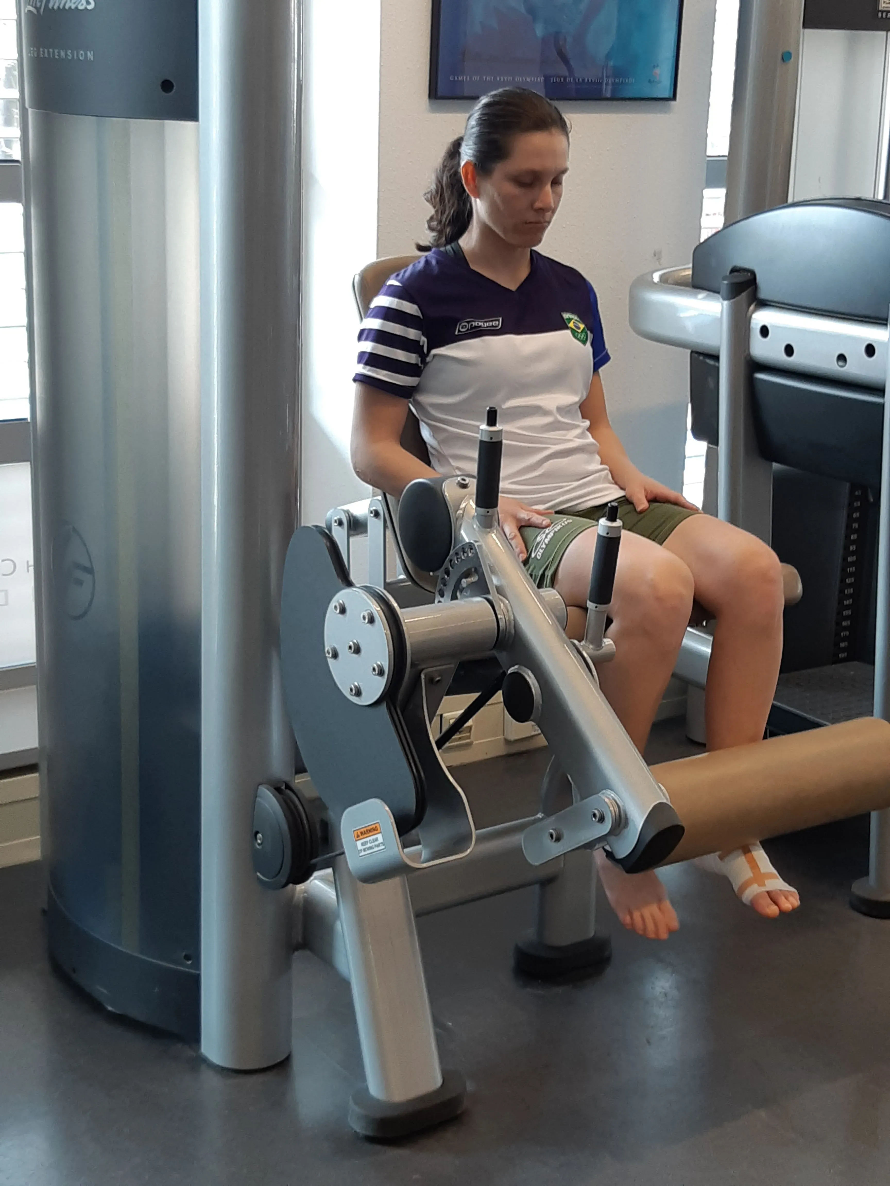 تتدرب برونا مورا، الرياضية البرازيلية، على جهاز رياضي في صالة الألعاب، مستعدة لتحقيق حلمها الأولمبي بعد تحديات عديدة.