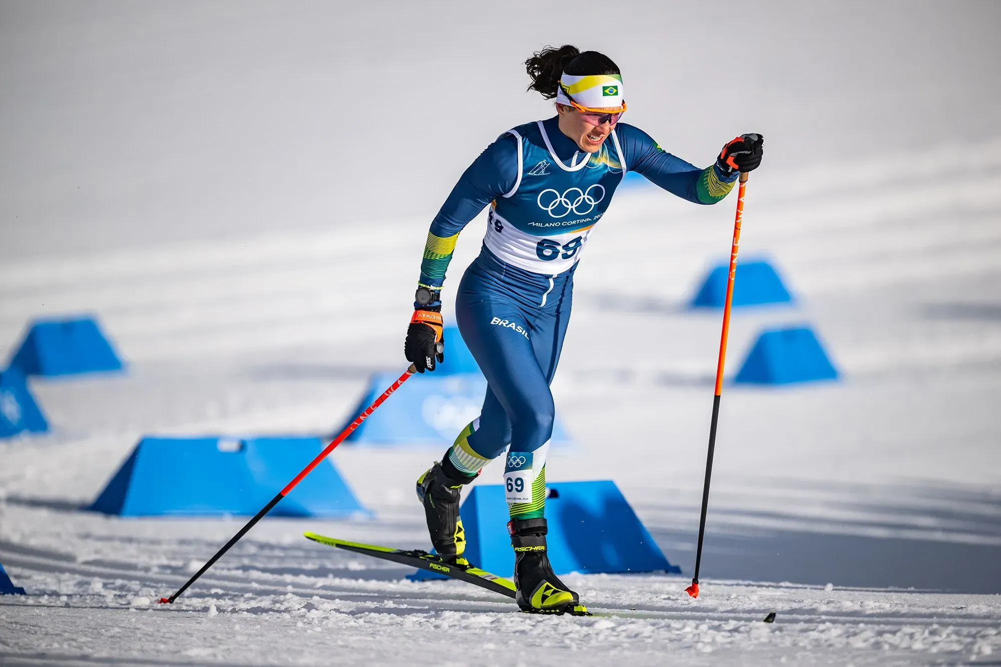 مورا تتزلج في أولمبياد بكين 2022، مرتدية زي الفريق البرازيلي، مع التركيز على المنافسة في ظروف ثلجية.