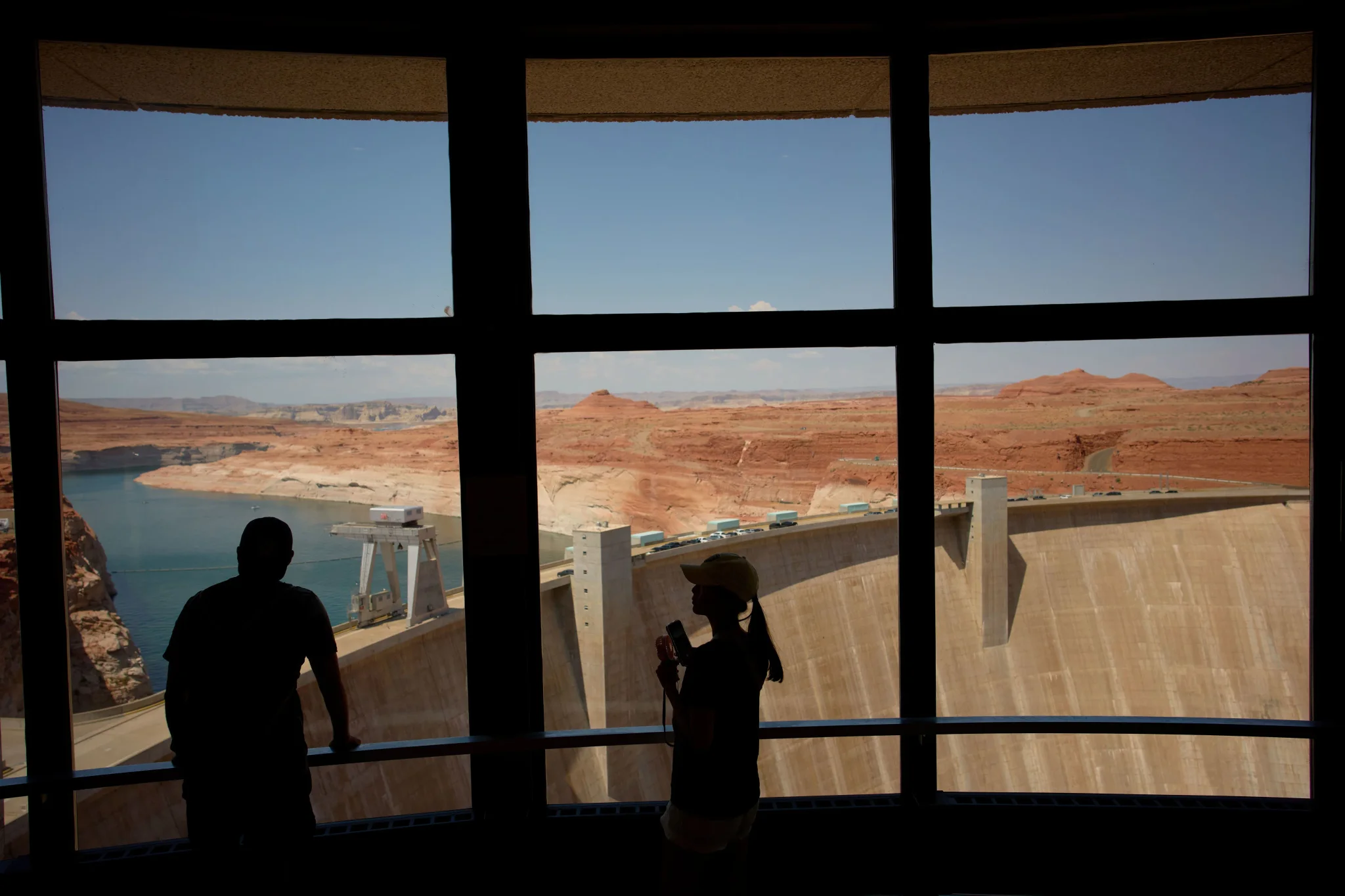 منظر داخلي لسد Glen Canyon مع شخصين ظليين يطلان على بحيرة Powell المنخفضة المستوى في ظل أزمة مياه نهر Colorado.