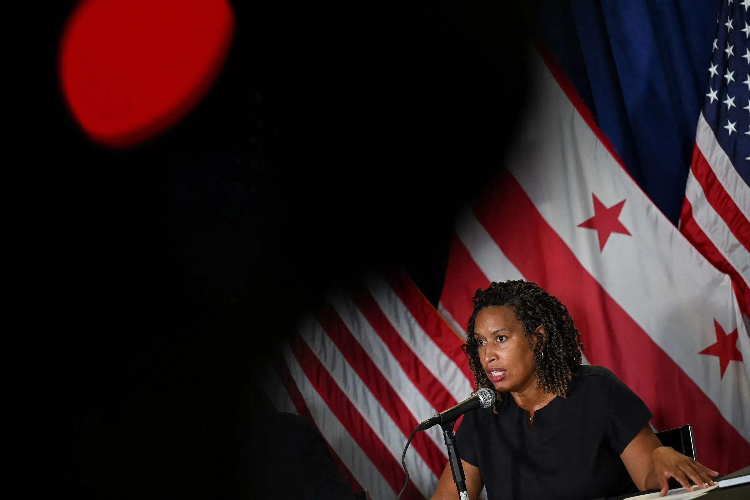 عمدة واشنطن موريل باوزر تتحدث خلال مؤتمر صحفي، مع ظهور العلم الأمريكي في الخلفية، في سياق مناقشة الأمن والجريمة في العاصمة.