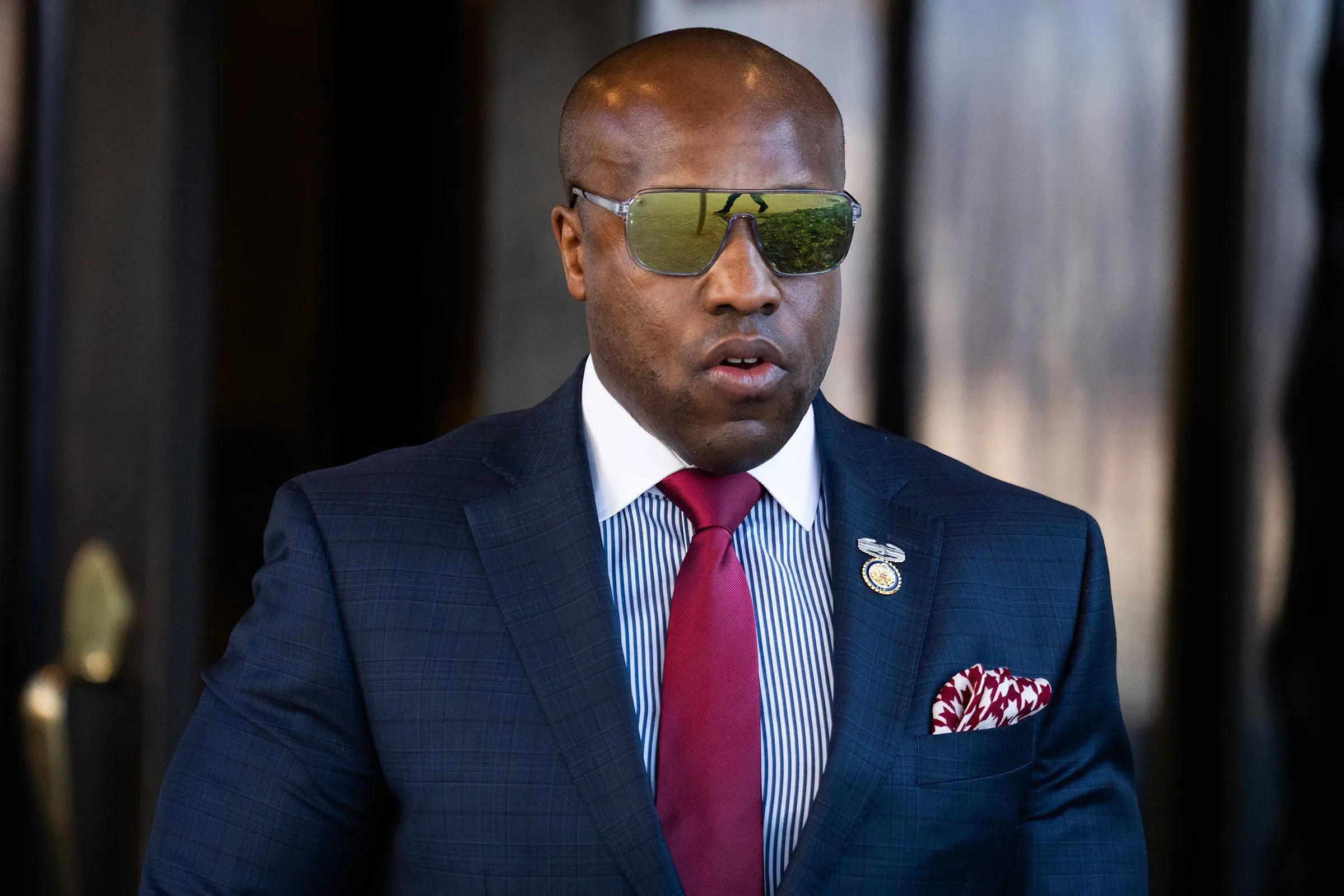 النائب ويسلي هانت، مرتديًا نظارات شمسية، يخرج من مبنى، معبرًا عن تصميمه على الاستمرار في سباق مجلس الشيوخ بولاية تكساس.