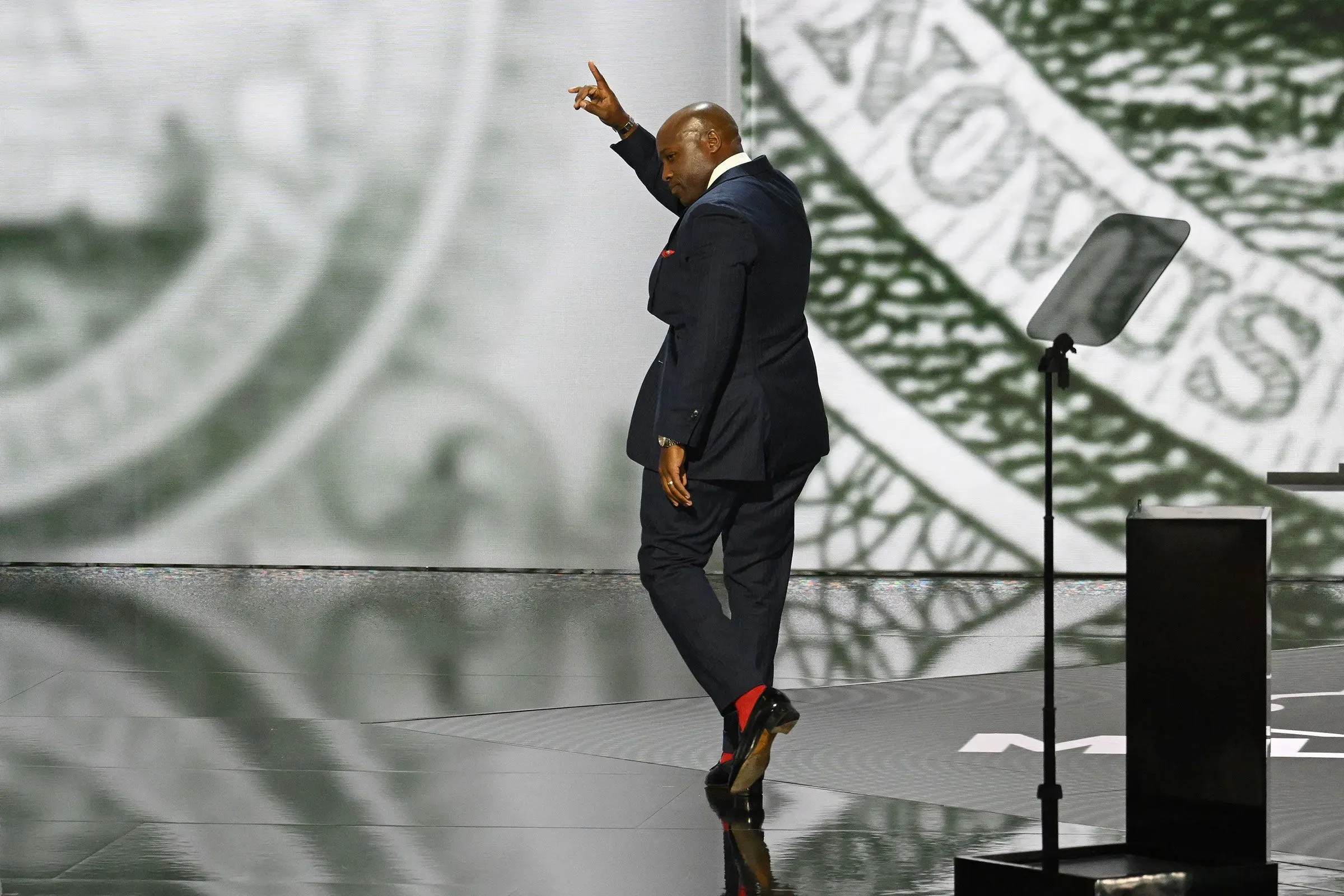 نائب جمهوري يسير على المسرح أثناء حديثه عن ترشحه لمجلس الشيوخ في تكساس، مع خلفية توضح أهمية الانتخابات.