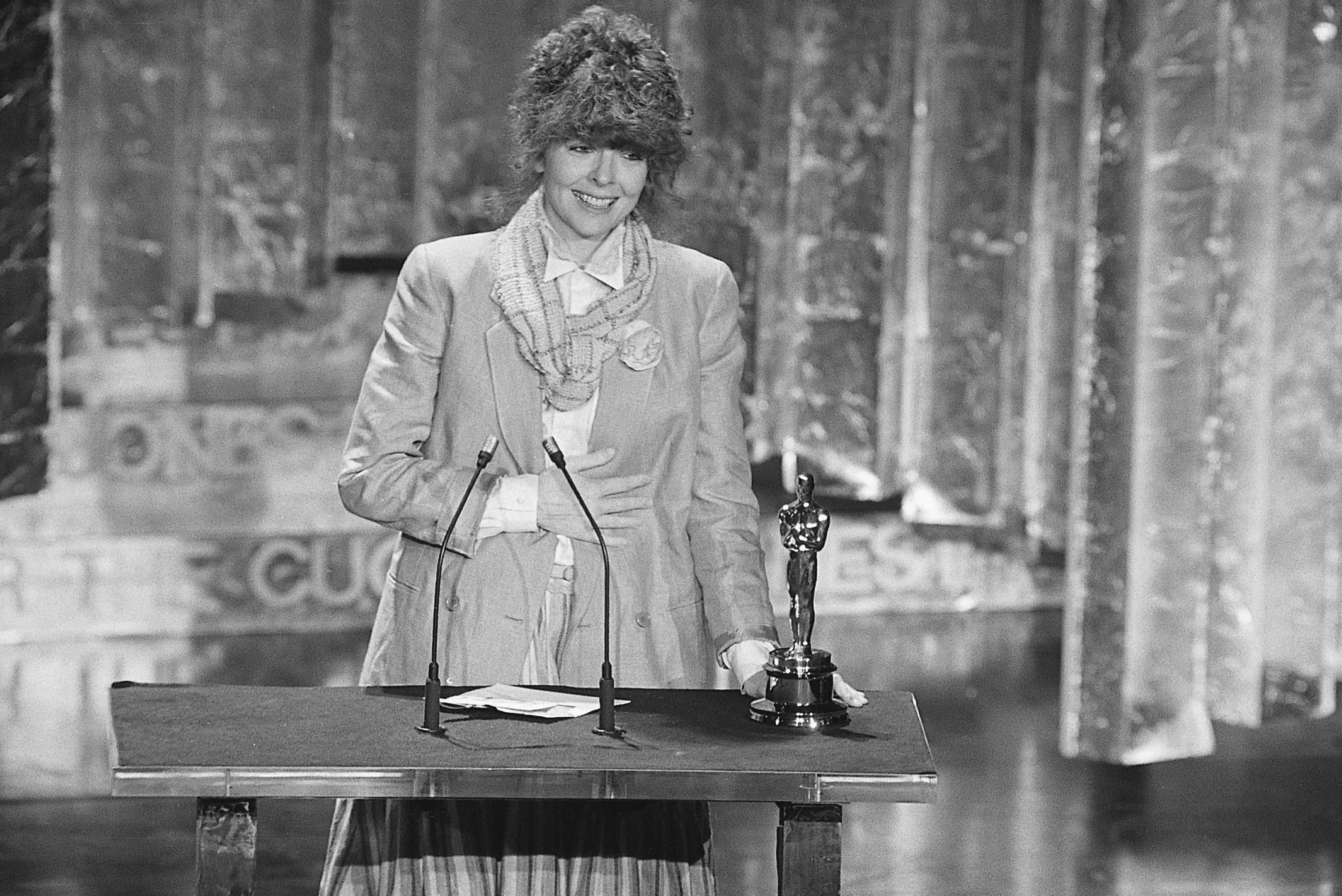 ديان كيتون تتسلم جائزة الأوسكار لأفضل ممثلة عام 1977، مرتدية زيًا مميزًا يعكس أسلوبها الفريد في الكوميديا.