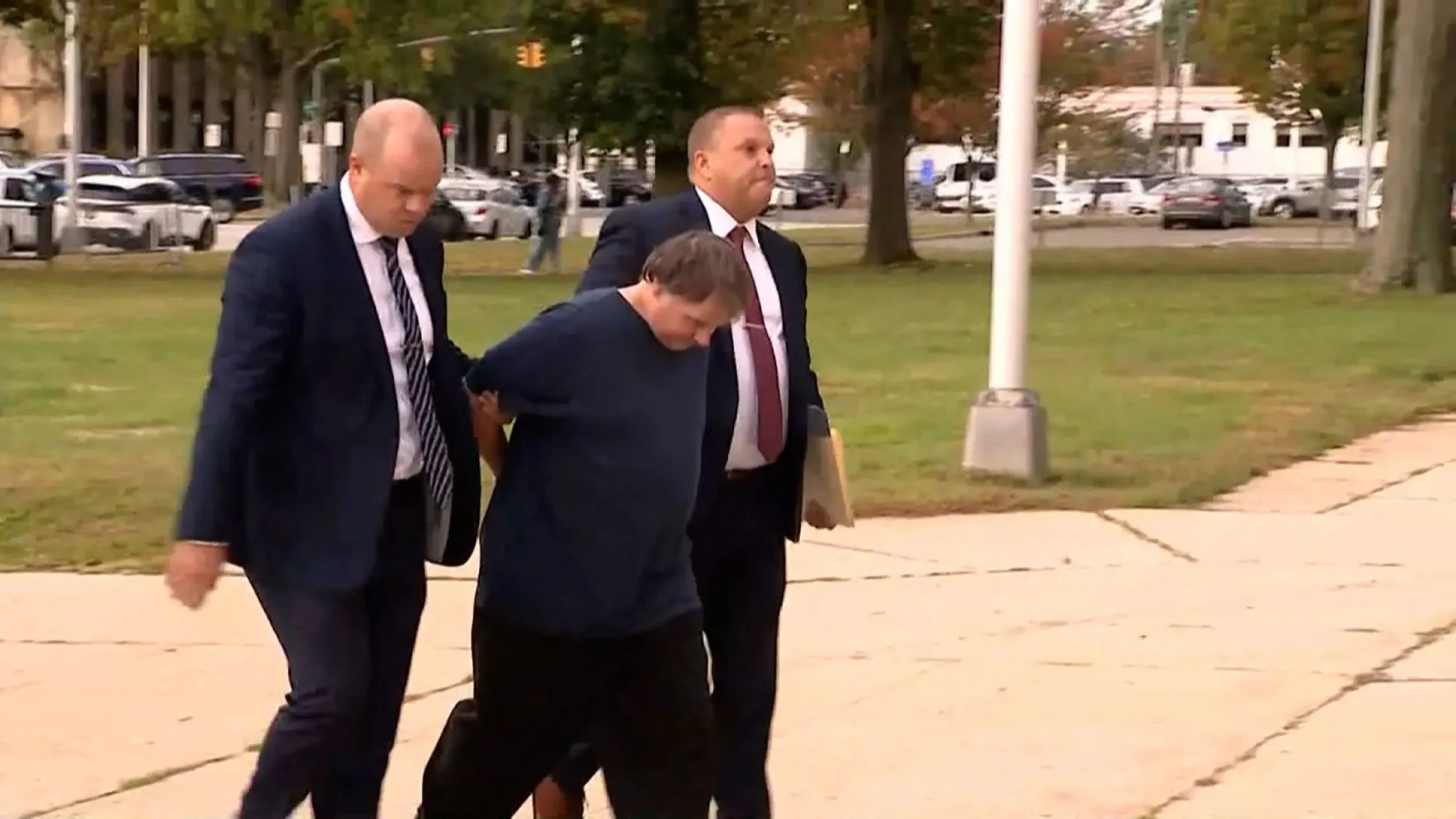 رجل يُحتجز من قبل محققين أثناء مغادرته المحكمة في لونغ آيلاند، حيث وُجهت إليه تهمة قتل تيريزا فوسكو في عام 1984.