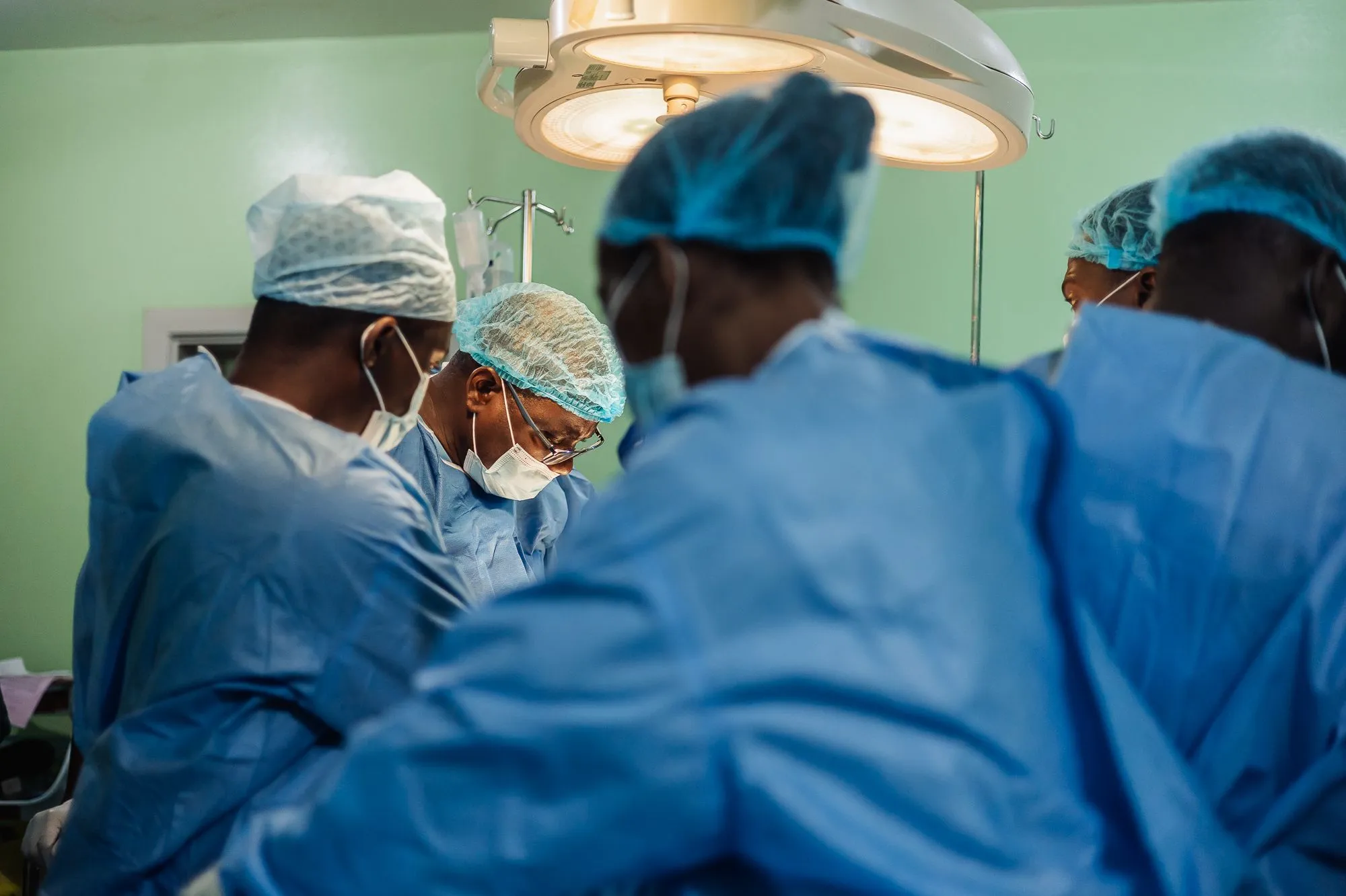 فريق جراحي نيجيري يرتدي ملابس العمليات ويجري جراحة في مستشفى جامعة Obafemi Awolowo لمواجهة سرطان القولون والمستقيم المتزايد في نيجيريا.